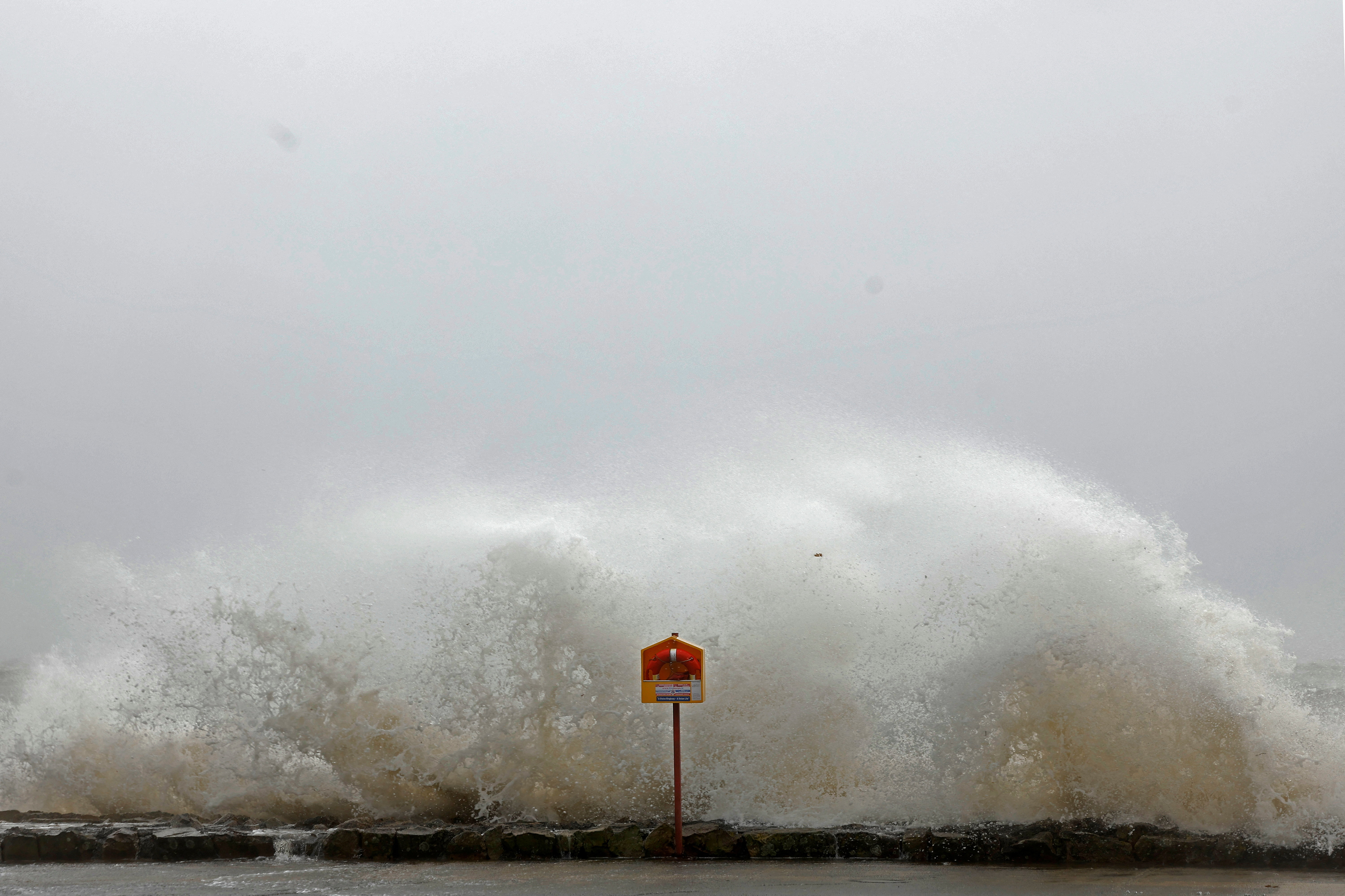 A wave splashes over a lifebuoy during Storm Amy which brought severe weather, in Galway, Ireland, October 3, 2025. REUTERS/Clodagh Kilcoyne