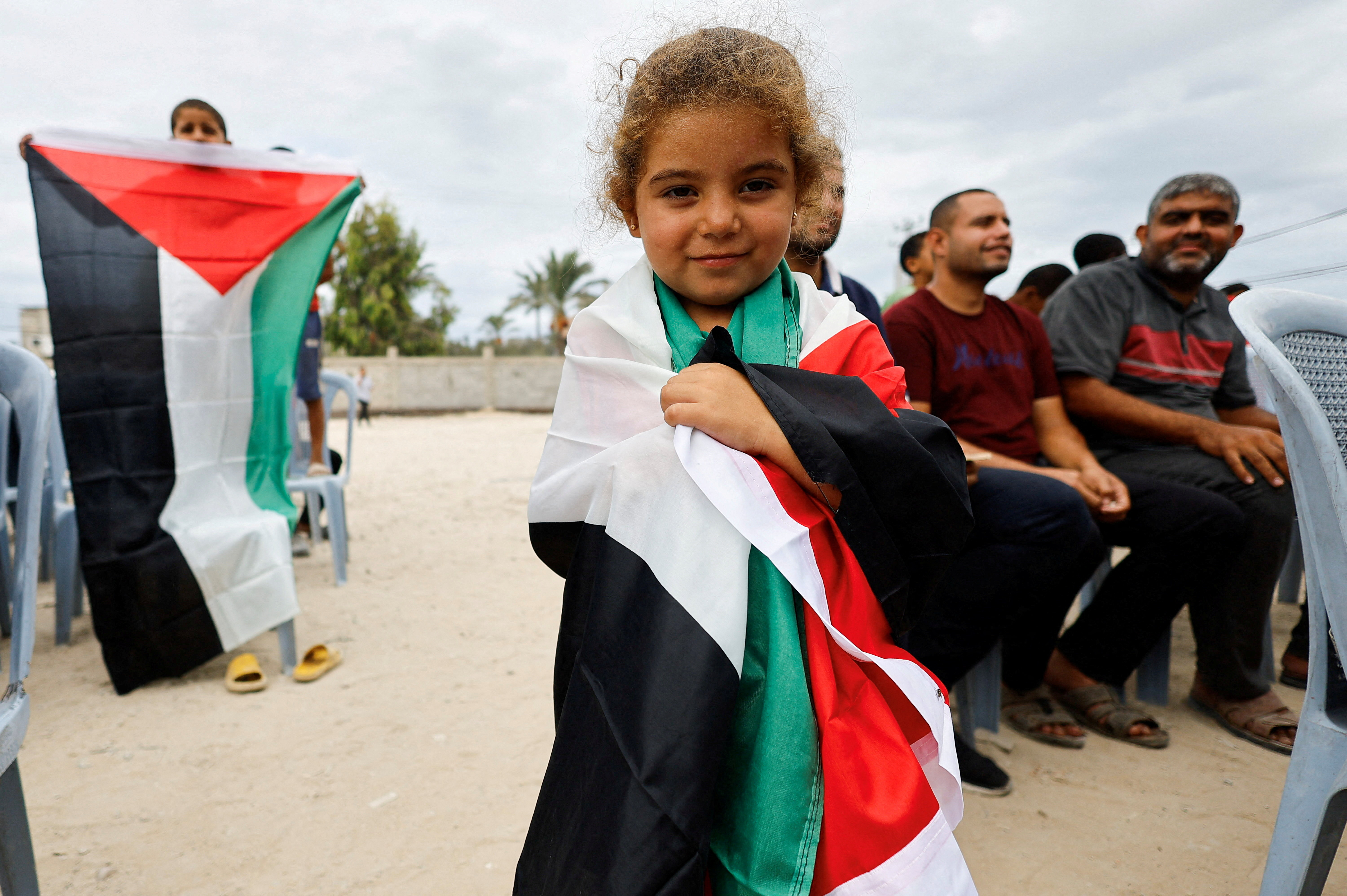 A girl holds a Palestinian flag, after U.S. President Donald Trump announced that Israel and Hamas agreed on the first phase of a Gaza ceasefire, in the central Gaza Strip October 9, 2025.