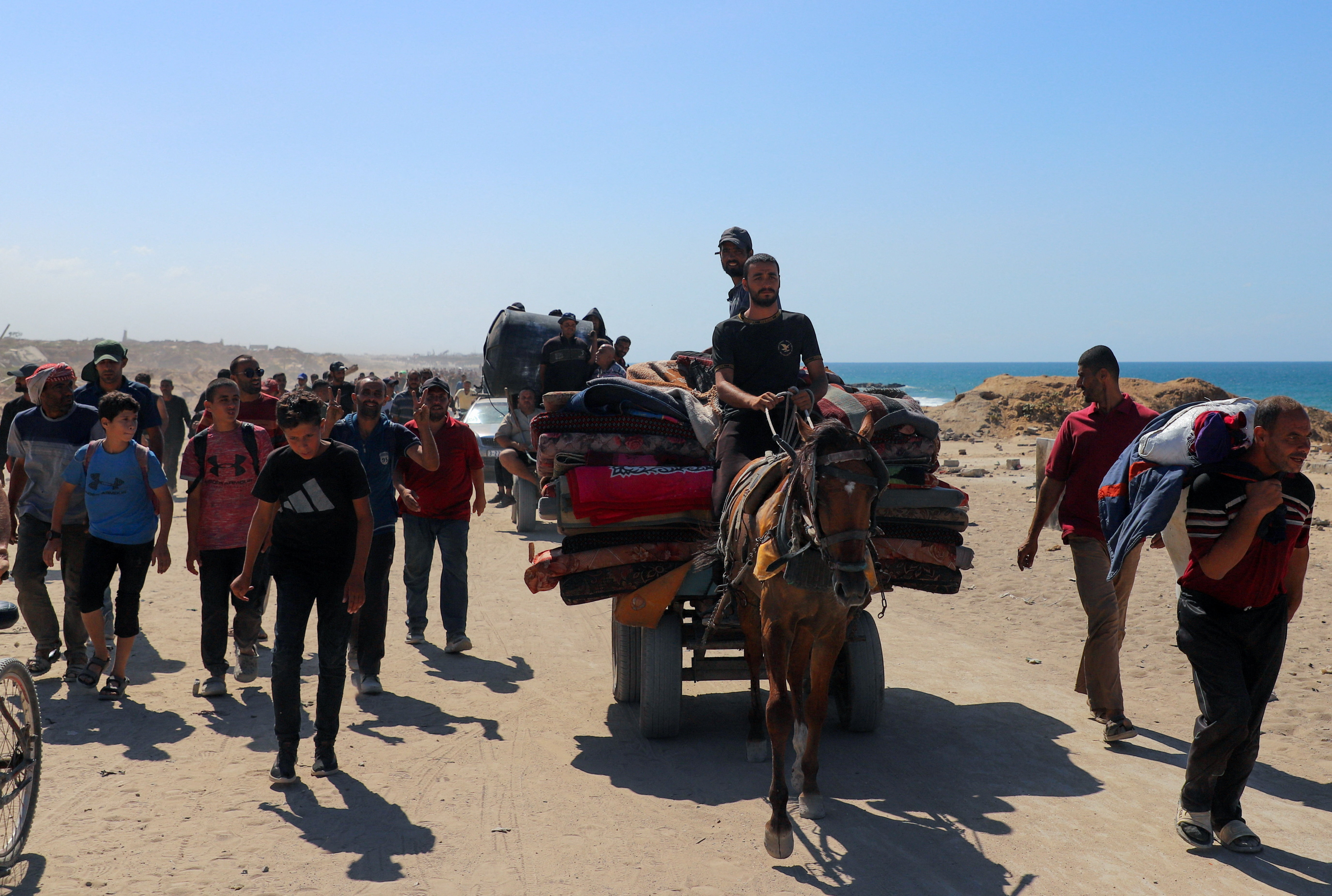 Palestinians, who were displaced to the southern part of Gaza at Israel's order during the war, make their way following their arrival in Gaza City after a ceasefire between Israel and Hamas