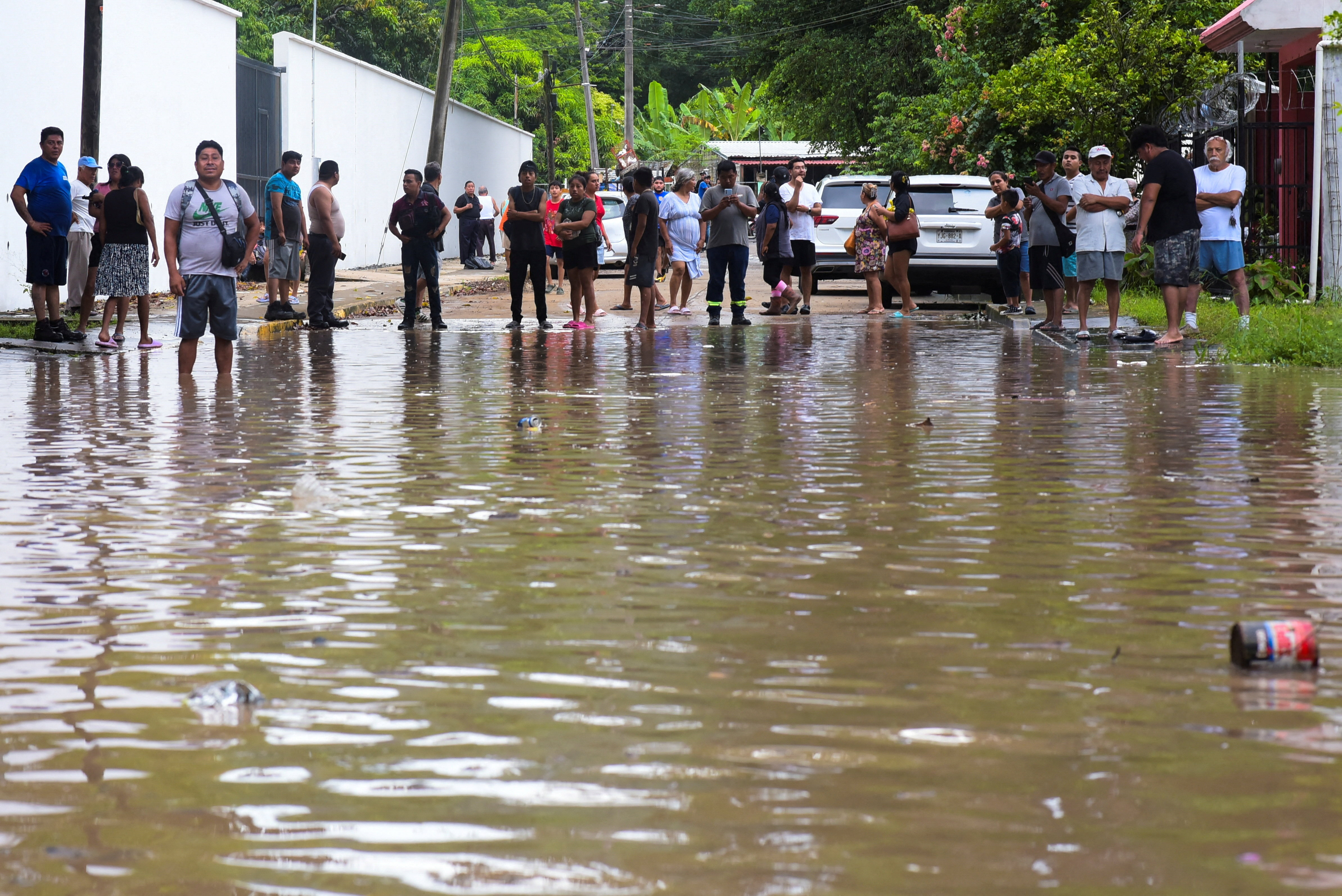 People look at a flooded street after torrential rains that caused an overflow of rivers in Poza Rica, Veracruz state, Mexico, October 10, 2025. REUTERS/Rolando Ramos