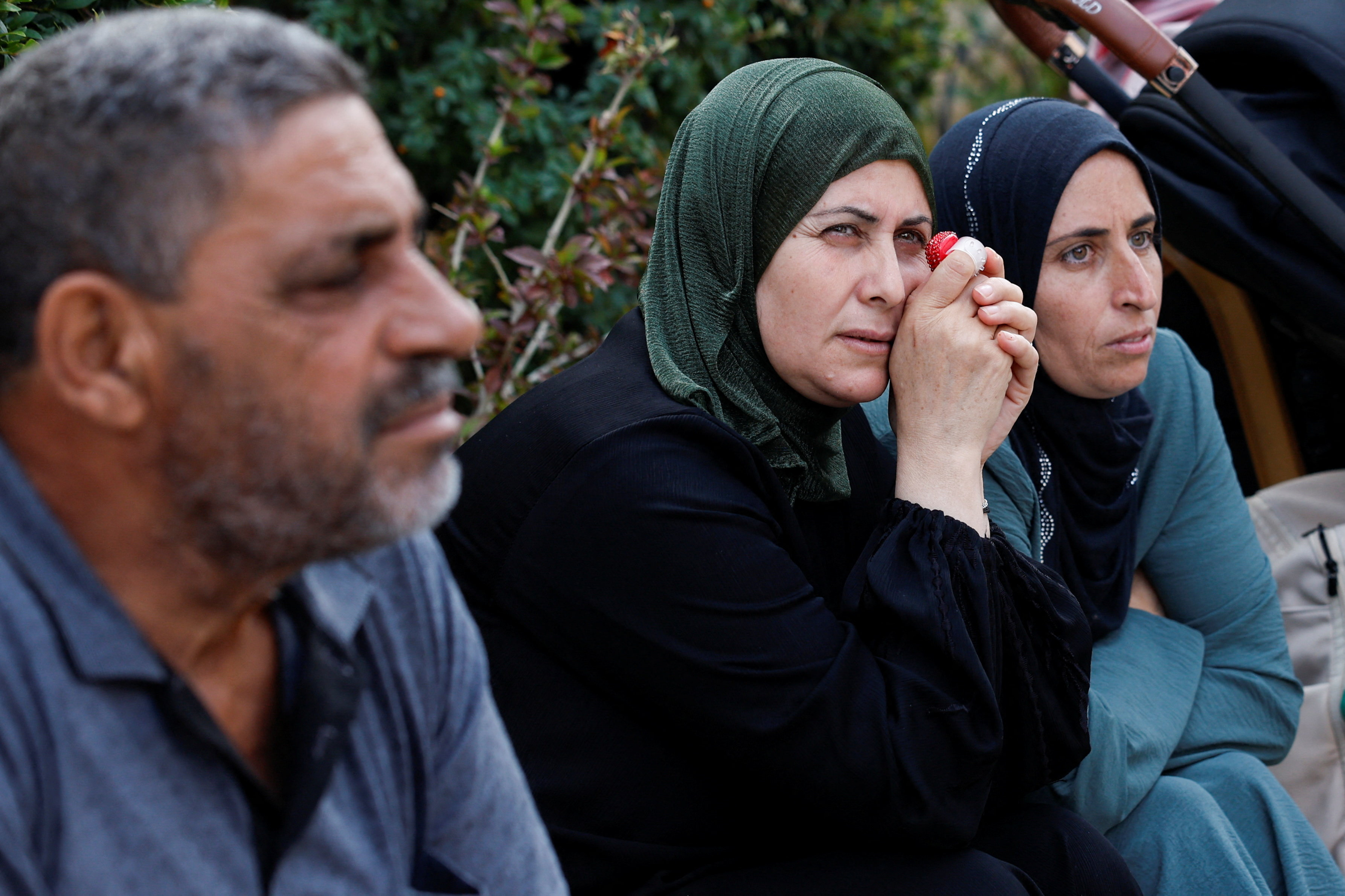 Families wait for their relatives on the day Palestinian prisoners are released from an Israeli jail as part of