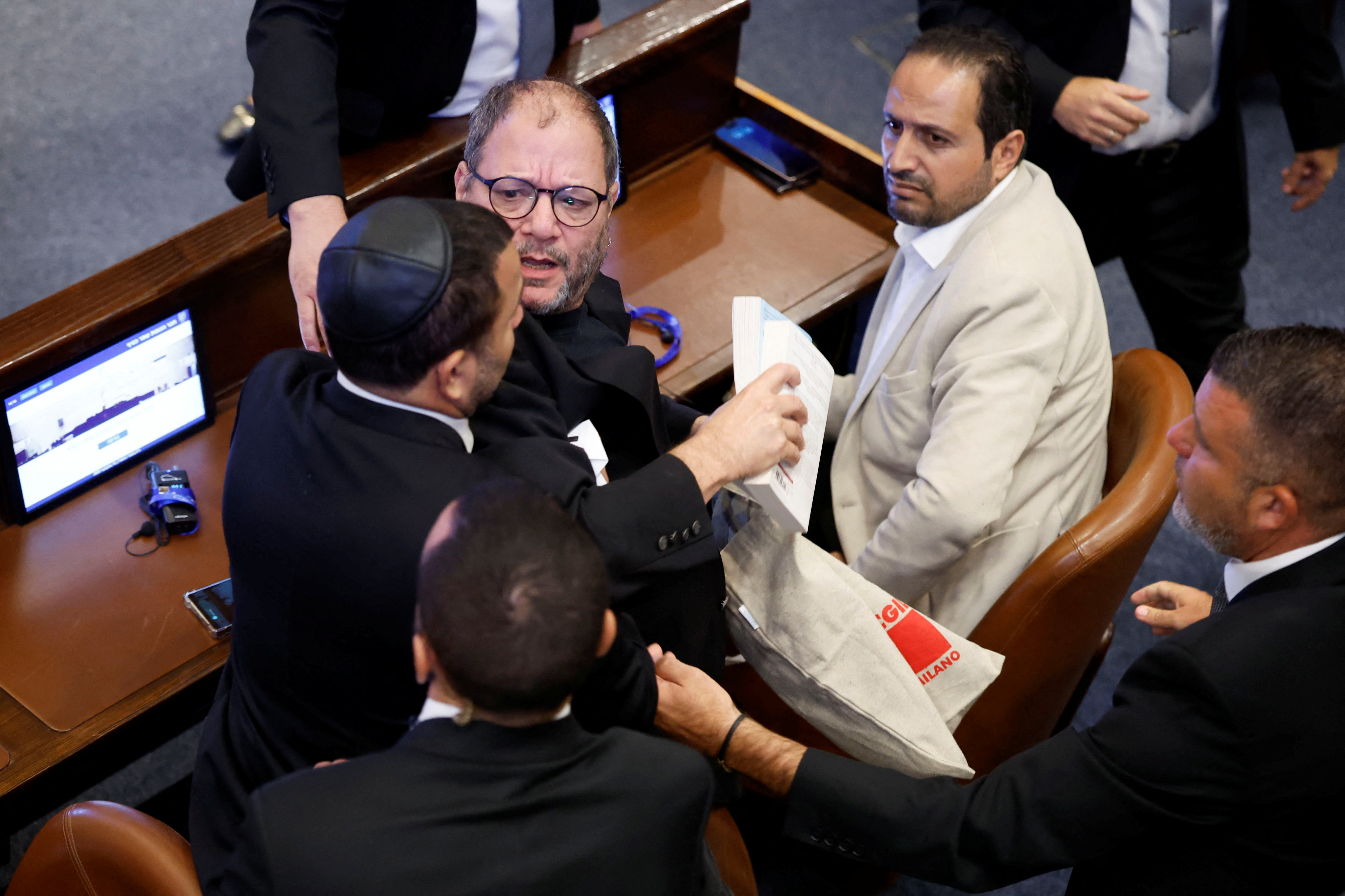 Knesset member Ofer Cassif is removed from the hall after raising a sign while U.S. President Donald Trump addresses the Knesset