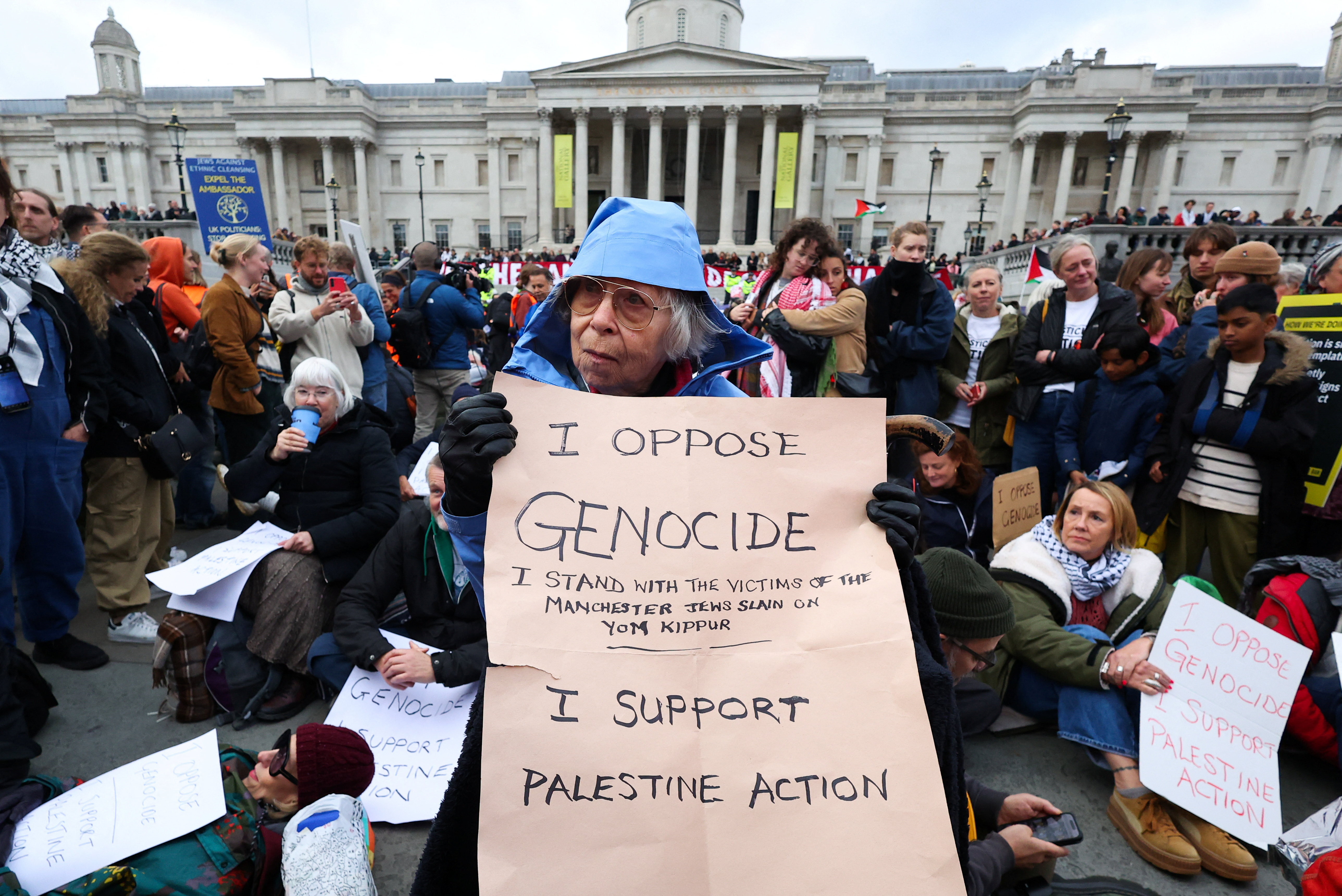 A protester holds a placard during a mass demonstration organised by Defend our Juries, against the British government's ban on Palestine Action, at Trafalgar Square in London, Britain, October 4, 2025.