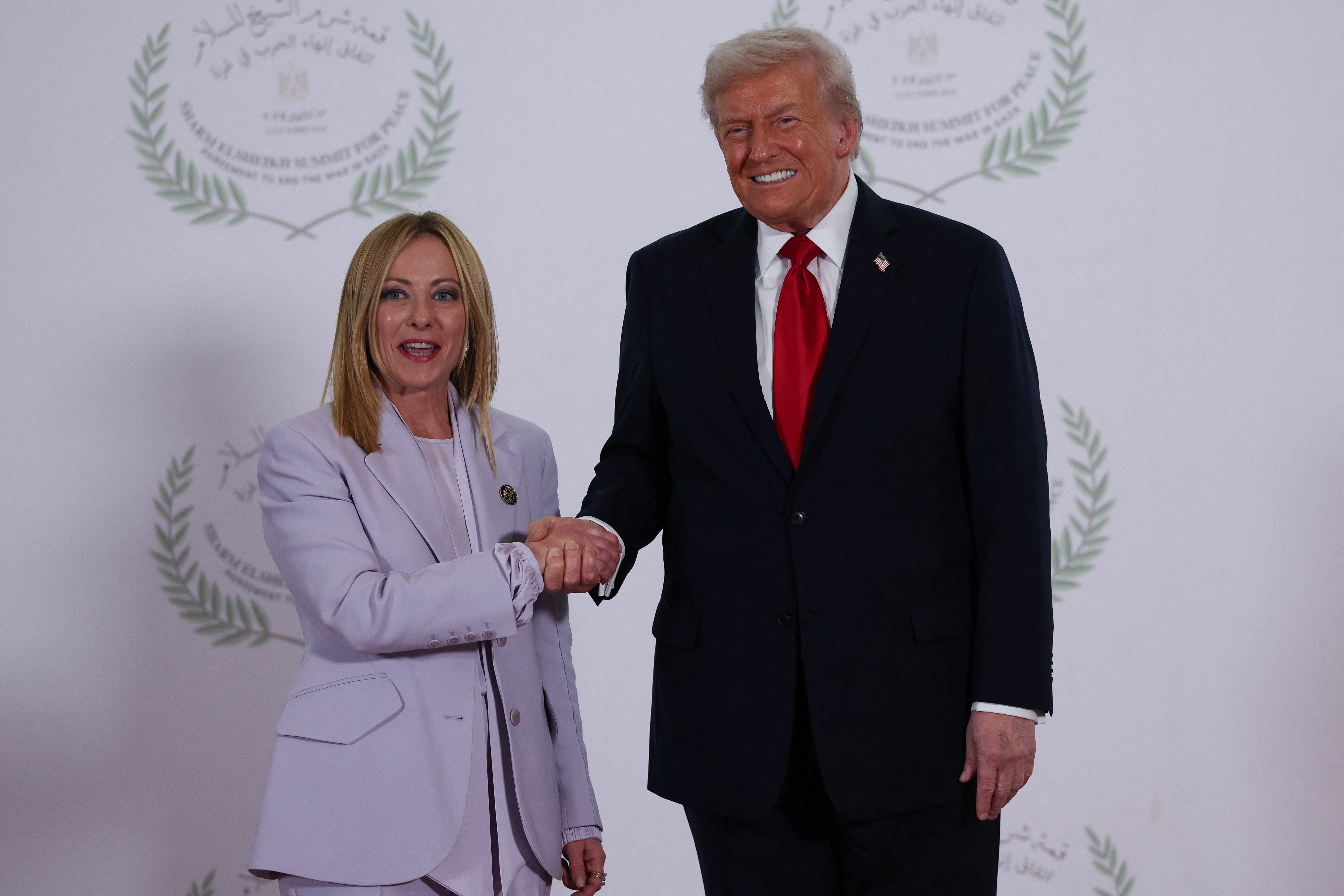 U.S. President Donald Trump and Italian Prime Minister Giorgia Meloni shake hands as they pose for a photo, at a world leaders' summit on ending the Gaza war