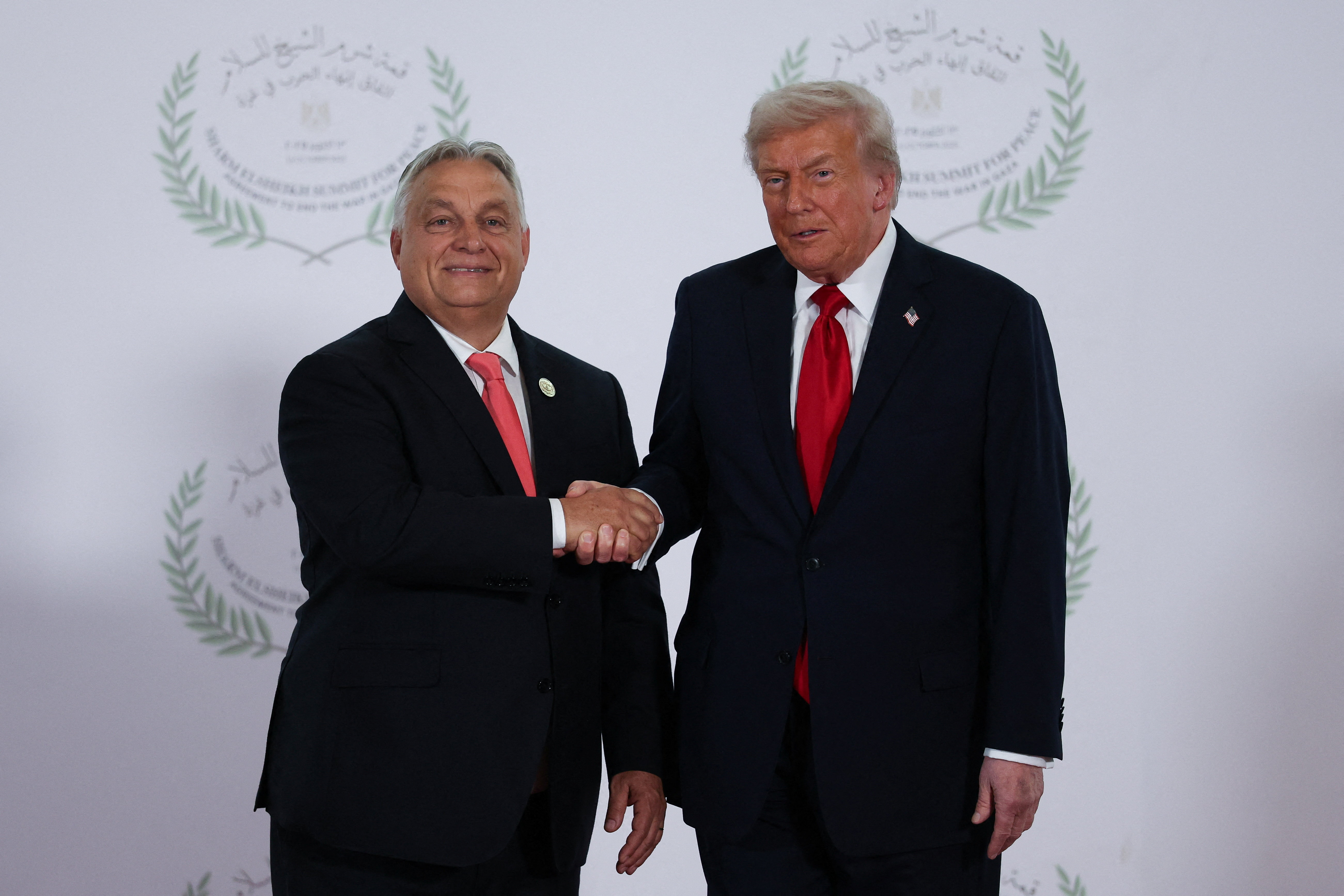 U.S. President Donald Trump and Hungarian Prime Minister Viktor Orban shake hands as they pose for a photo, at a world leaders' summit on ending the Gaza war