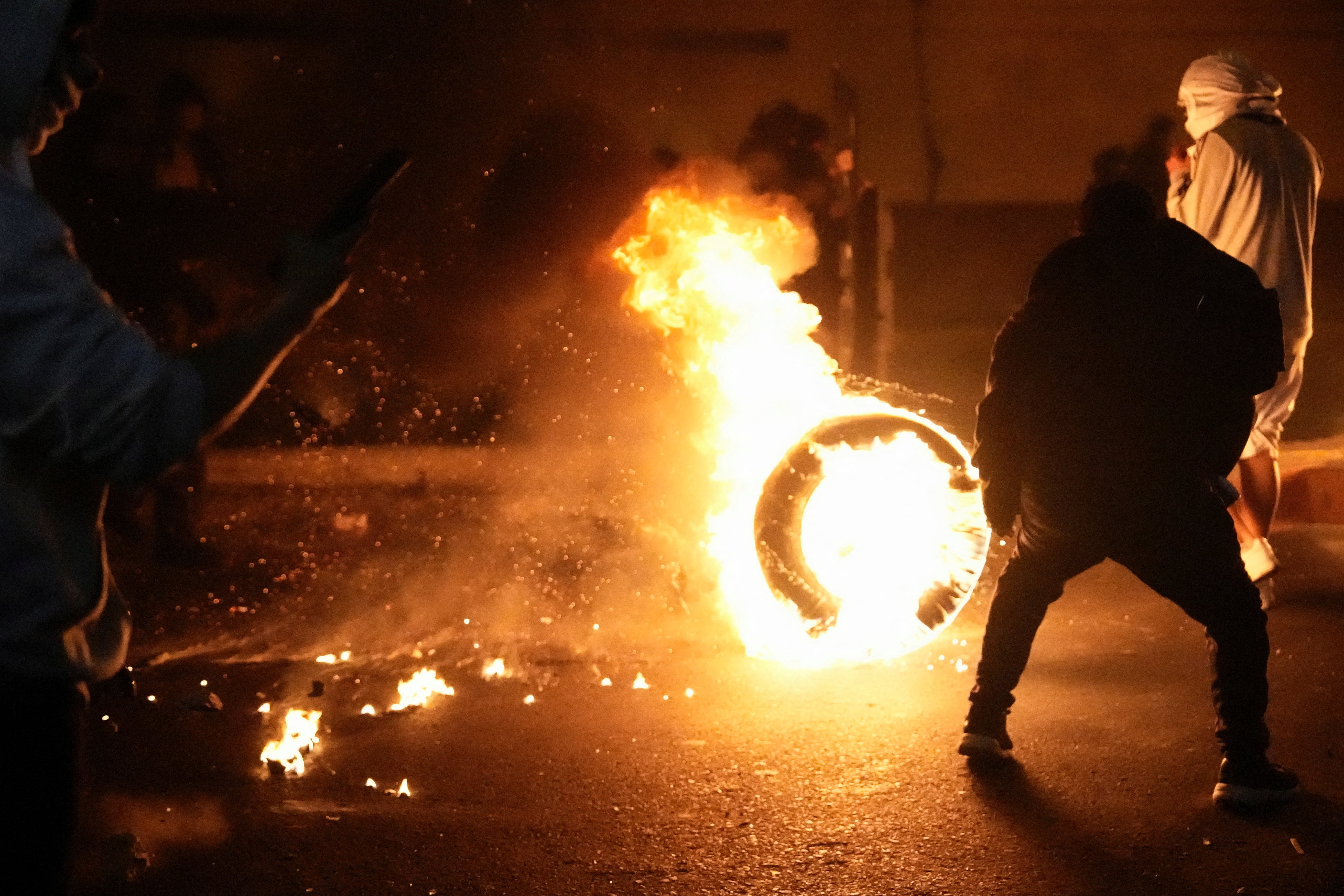 Demonstrators stand around a tyre on fire during a protest against rising crime, economic insecurity, and corruption, a day after President Jose Jeri presented his cabinet