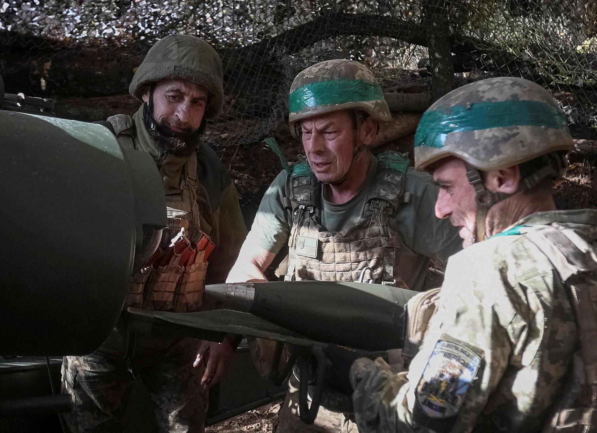 Artillerymen of the 152nd Separate Jaeger Brigade load a shell into an M114 self-propelled howitzer