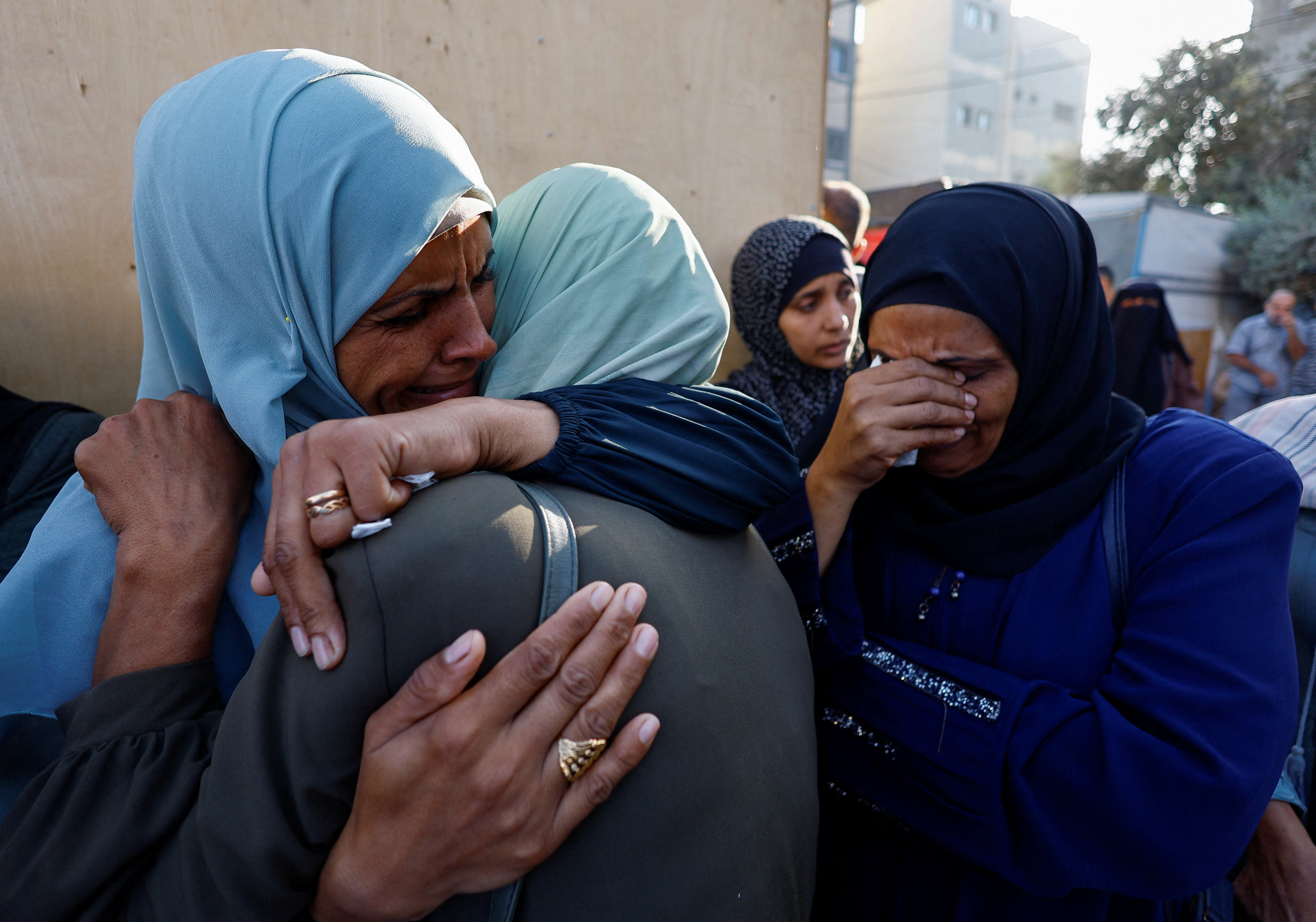 Mourners react as they attend the funeral of Palestinians killed in Sunday's Israeli strikes, according to medics, at al-Awda Hospital in the central Gaza Strip