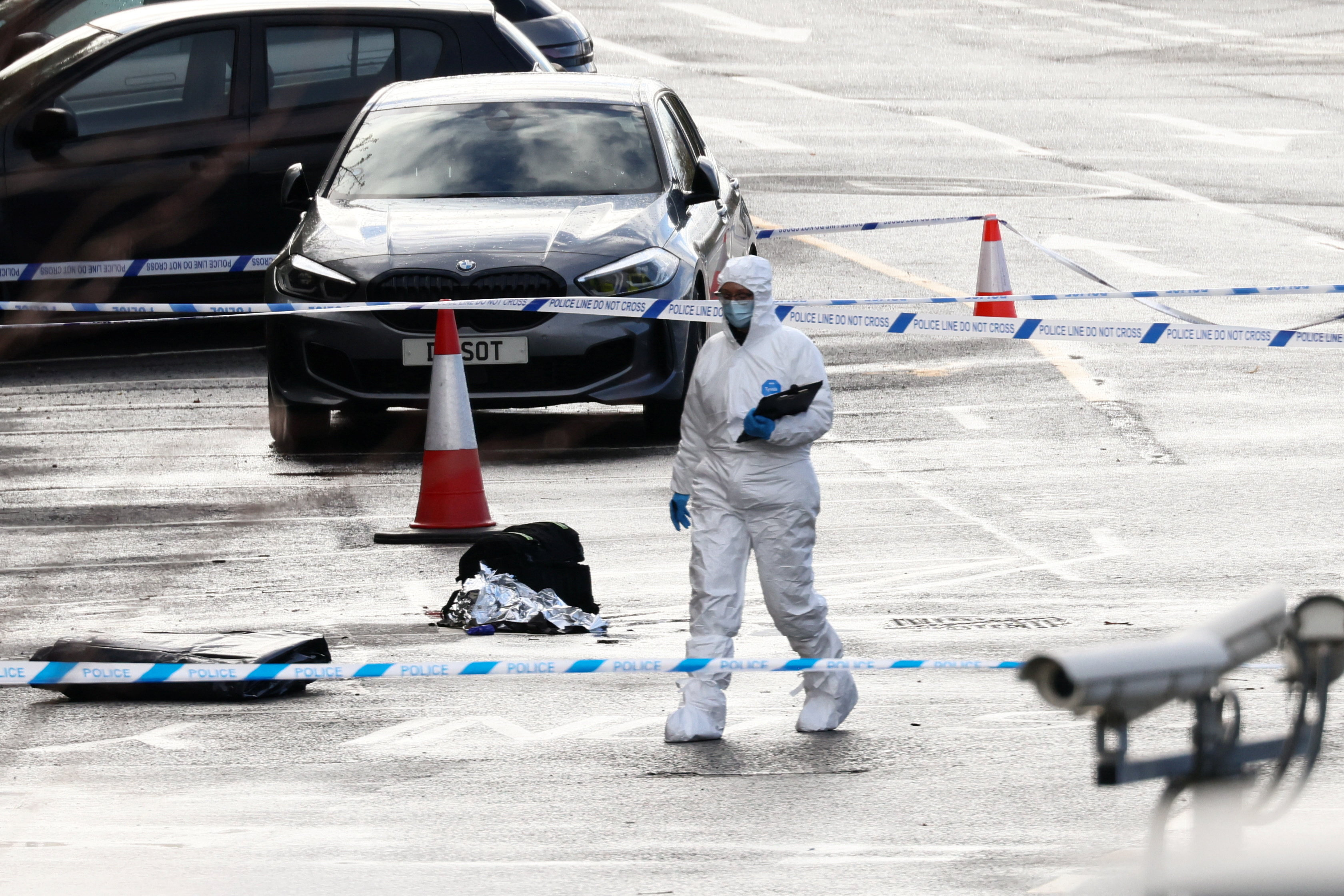 A forensic officer walks past a police cordon near Huntingdon Station, following a series of stabbings on a London North Eastern Railway (LNER) train, near Cambridge, Britain, November 2, 2025. REUTERS/Jack Taylor
