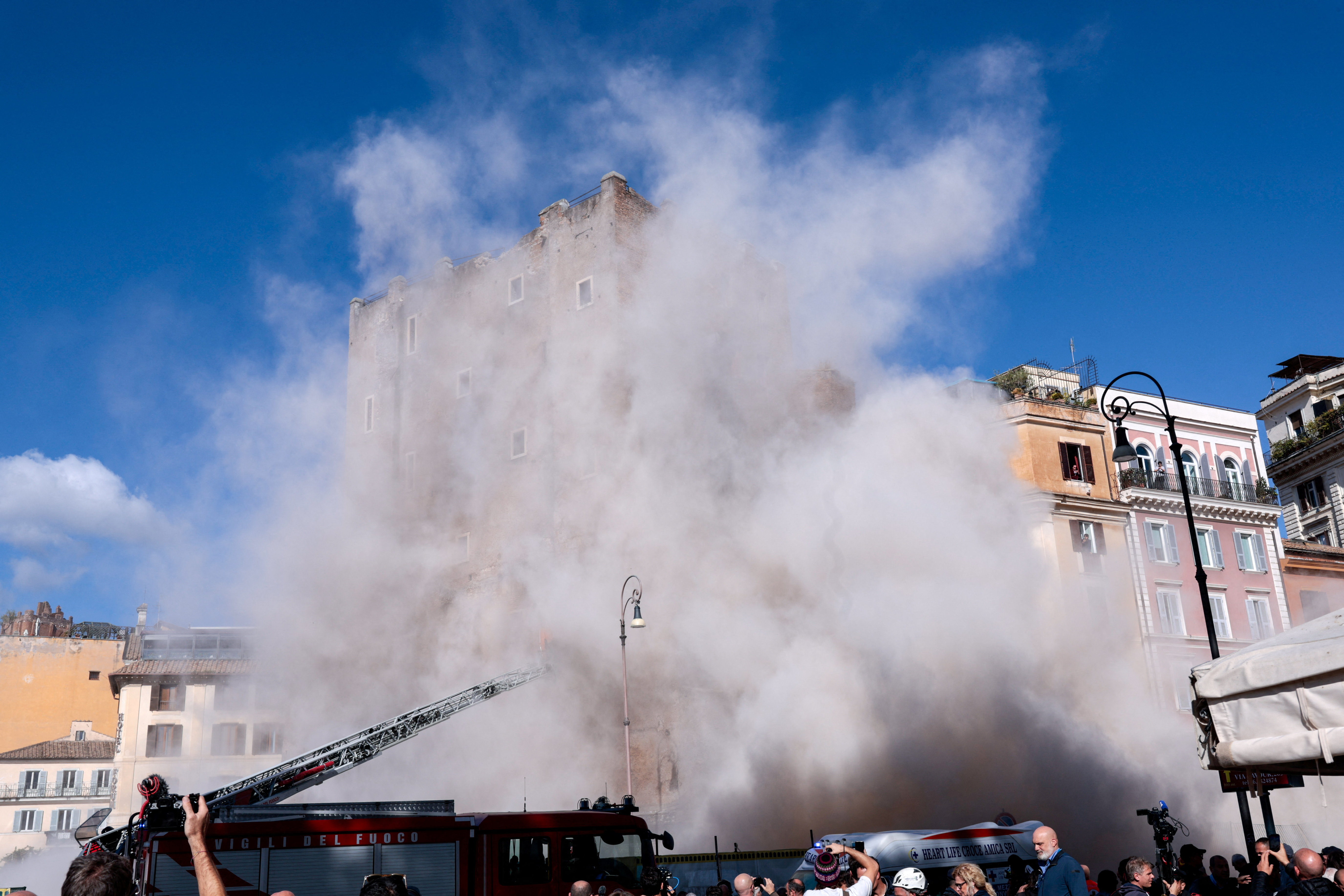 Dust rises as part of the Torre dei Conti tower collapses following an earlier partial collapse, near Via dei Fori Imperiali, near the Colosseum, in Rome, Italy, November 3, 2025. REUTERS/Remo Casilli     TPX IMAGES OF THE DAY