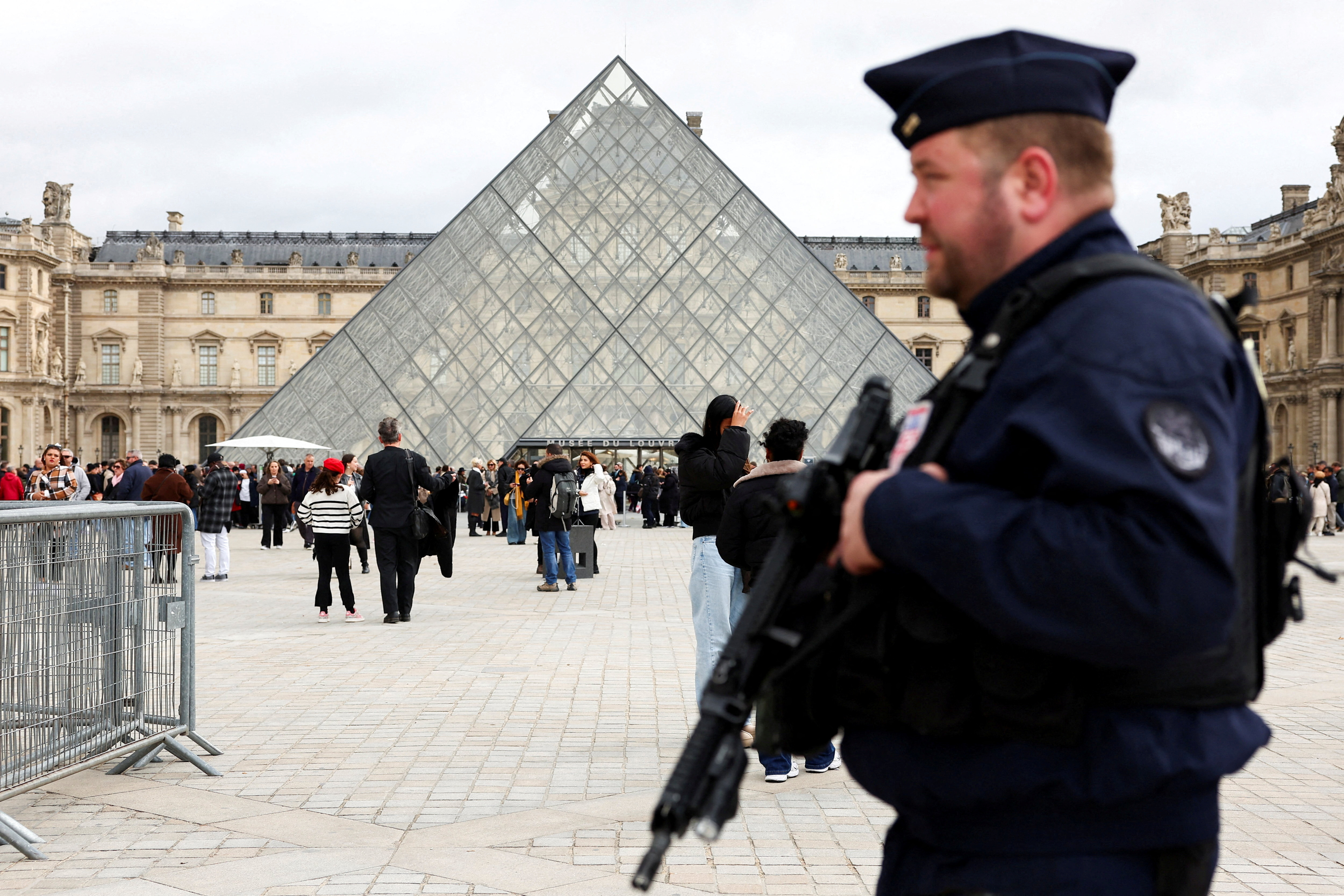 FILE PHOTO: A French CRS riot police officer patrols near the glass Pyramid of the Louvre Museum, after French police arrested suspects in the Louvre heist case, in Paris, France October 27, 2025. REUTERS/Abdul Saboor/File Photo