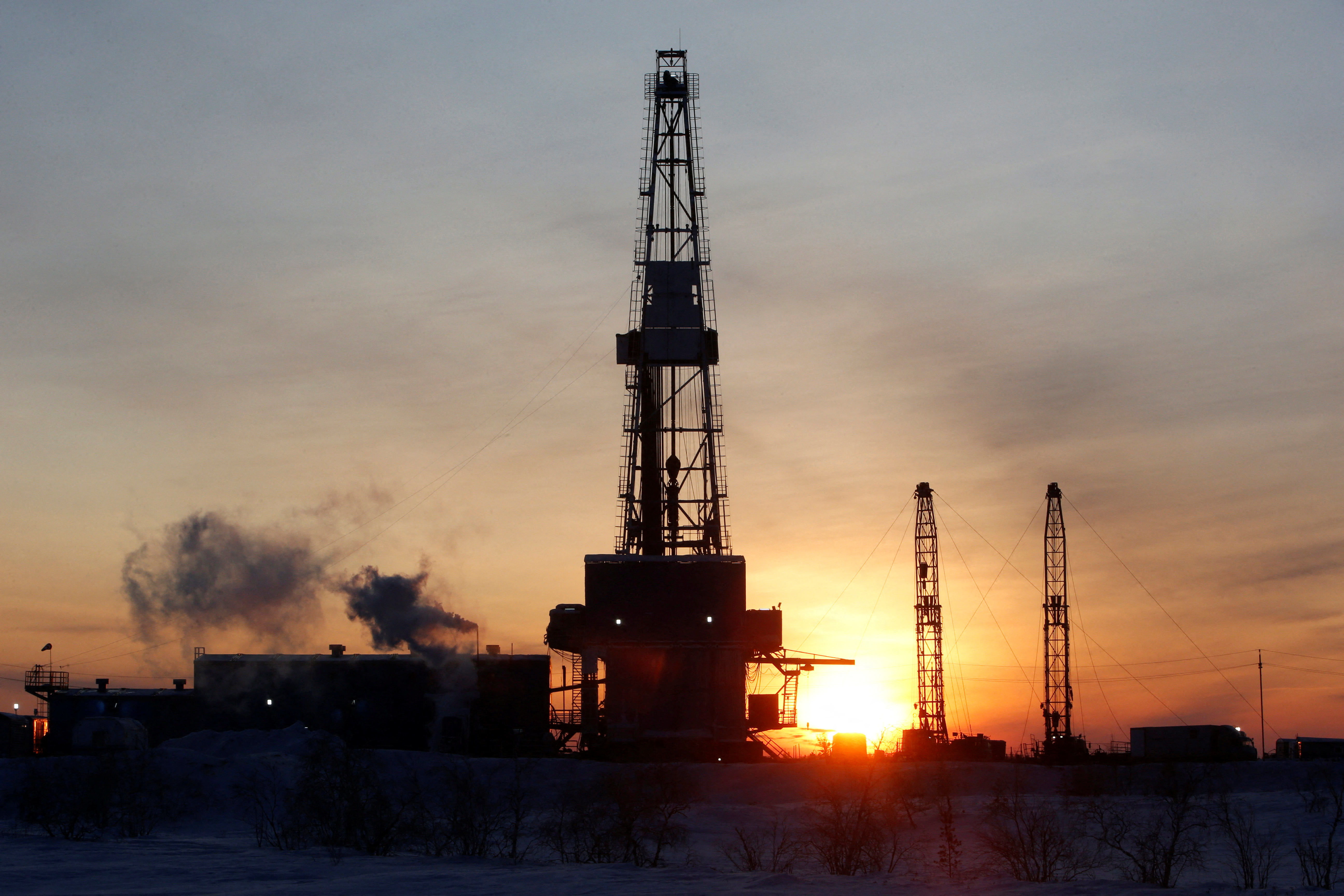 A general view shows an drilling rig at the Lukoil company owned Imilorskoye oil field, as the sun rises