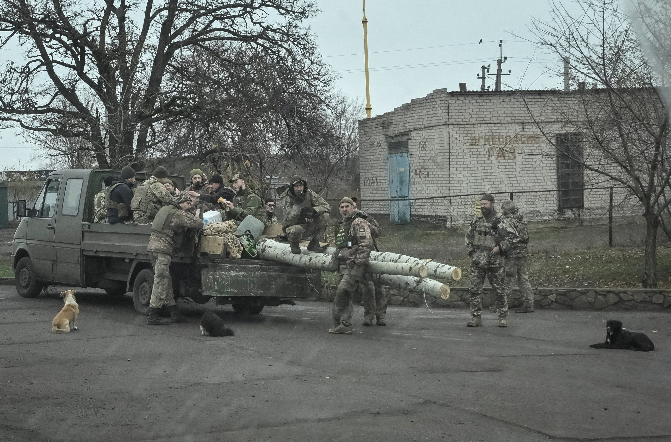 Ukrainian servicemen gather near a vehicle, seen through a window, amid Russia's attack on Ukraine, near the frontline town of Pokrovske, in Dnipropetrovsk region, Ukraine