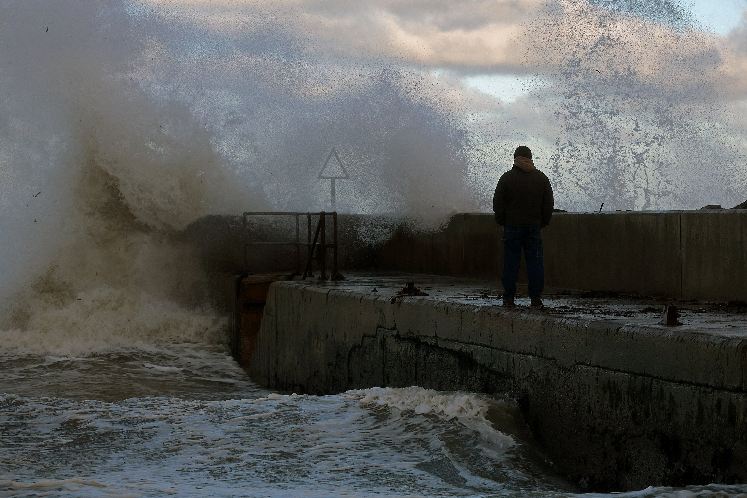 Waves crash on a pier in the coastal village of Cushendall, Northern Ireland, as Storm Claudia reaches parts of the United Kingdom, November 14, 2025.