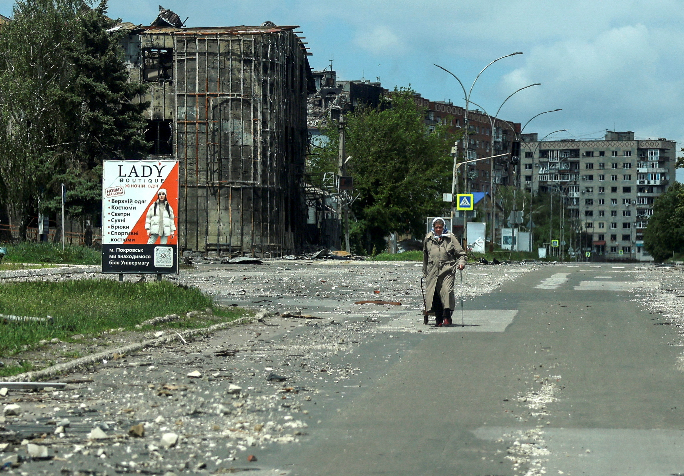 A resident walks at a street near buildings damaged by Russian military strikes, amid Russia's attack on Ukraine, in the frontline town of Pokrovsk, Donetsk region, Ukraine May 21, 2025. REUTERS/Anatolii Stepanov/File Photo
