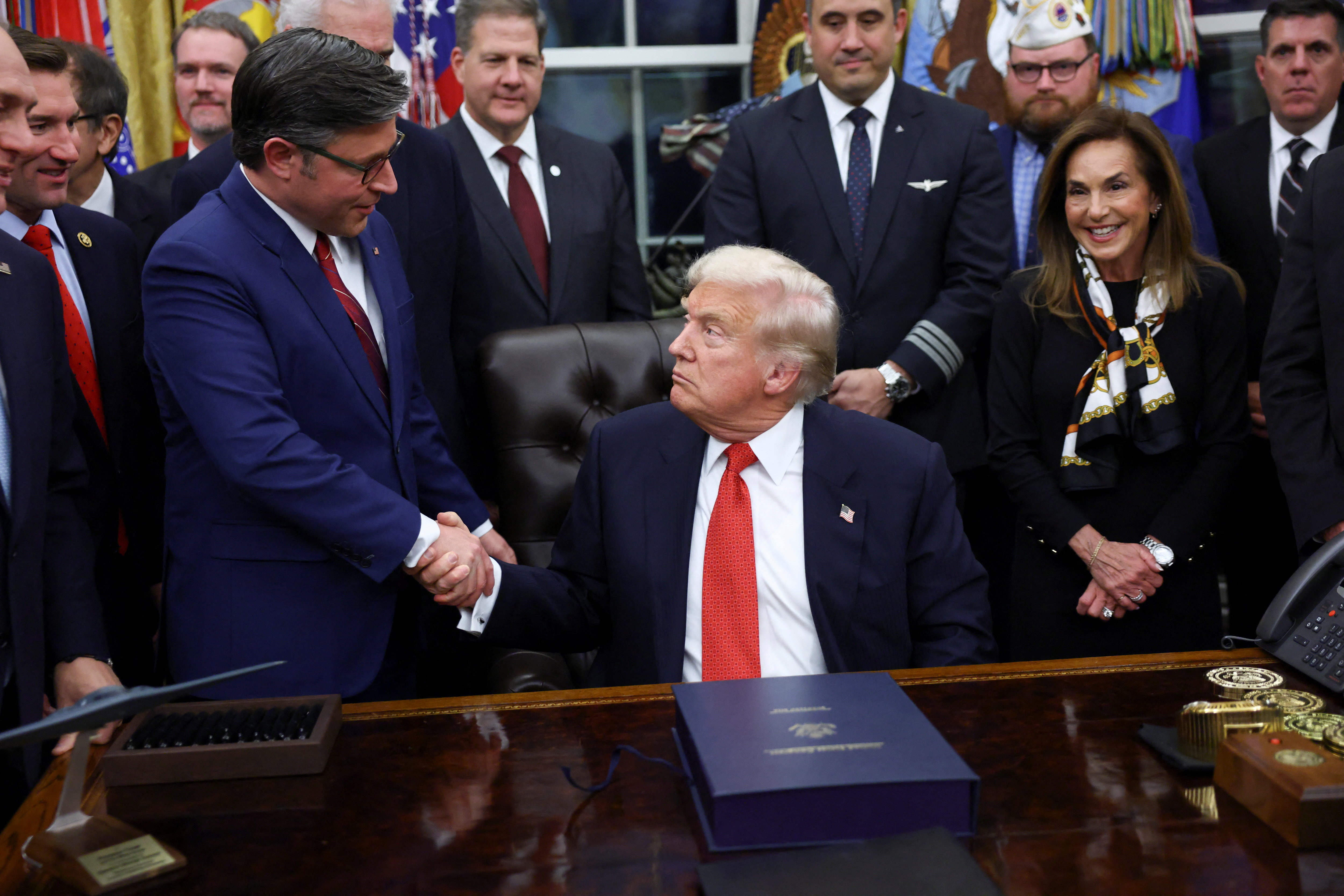 U.S. President Donald Trump shakes hands with U.S. House Speaker Mike Johnson (R-LA) after signing the funding bill to end the U.S. government shutdown, at the White House in Washington, D.C., U.S., November 12, 2025. REUTERS/Kevin Lamarque