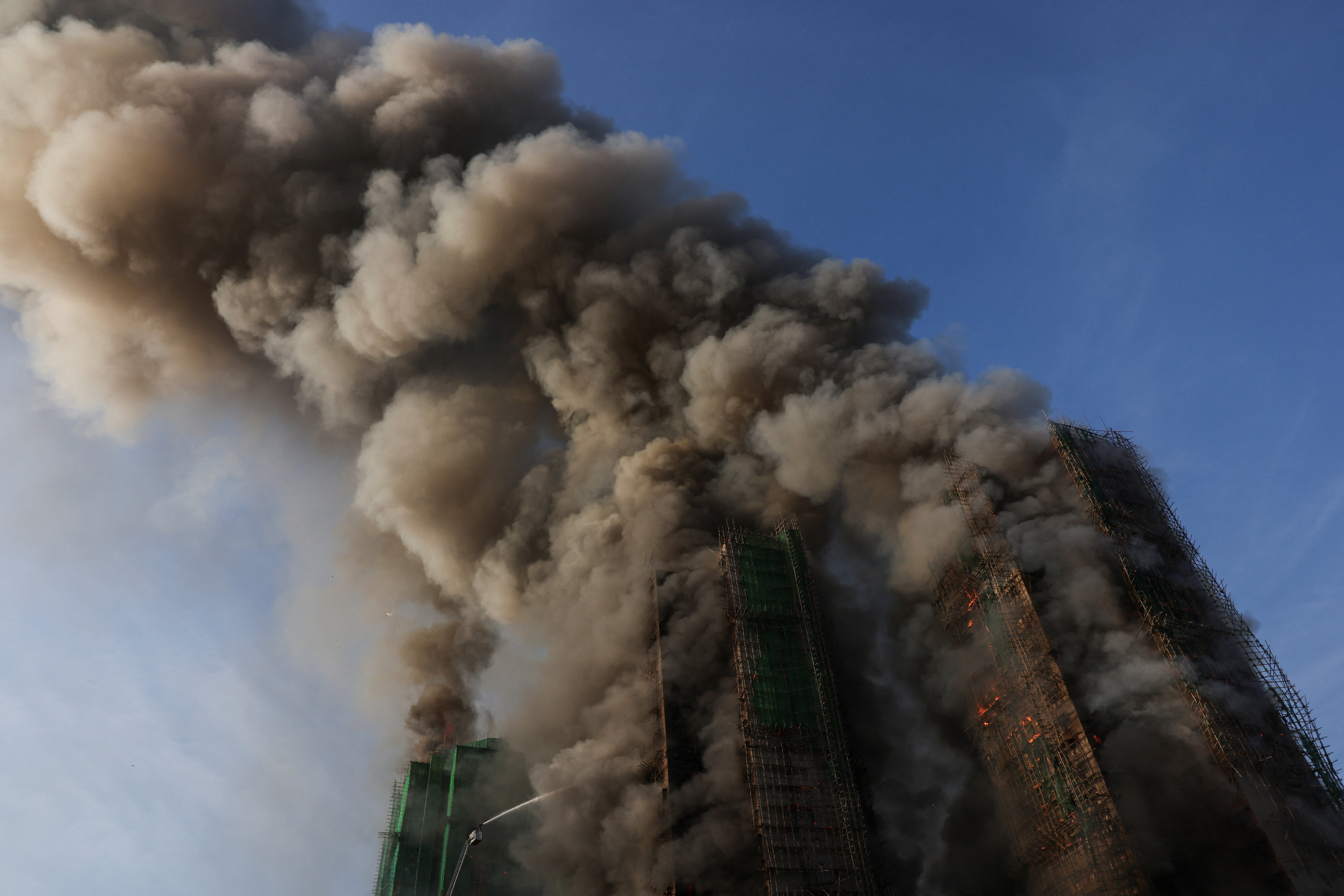 Smoke rises as flames engulf bamboo scaffolding across multiple buildings at Wang Fuk Court housing estate, in Tai Po, Hong Kong, China, November 26, 2025. REUTERS/Tyrone Siu