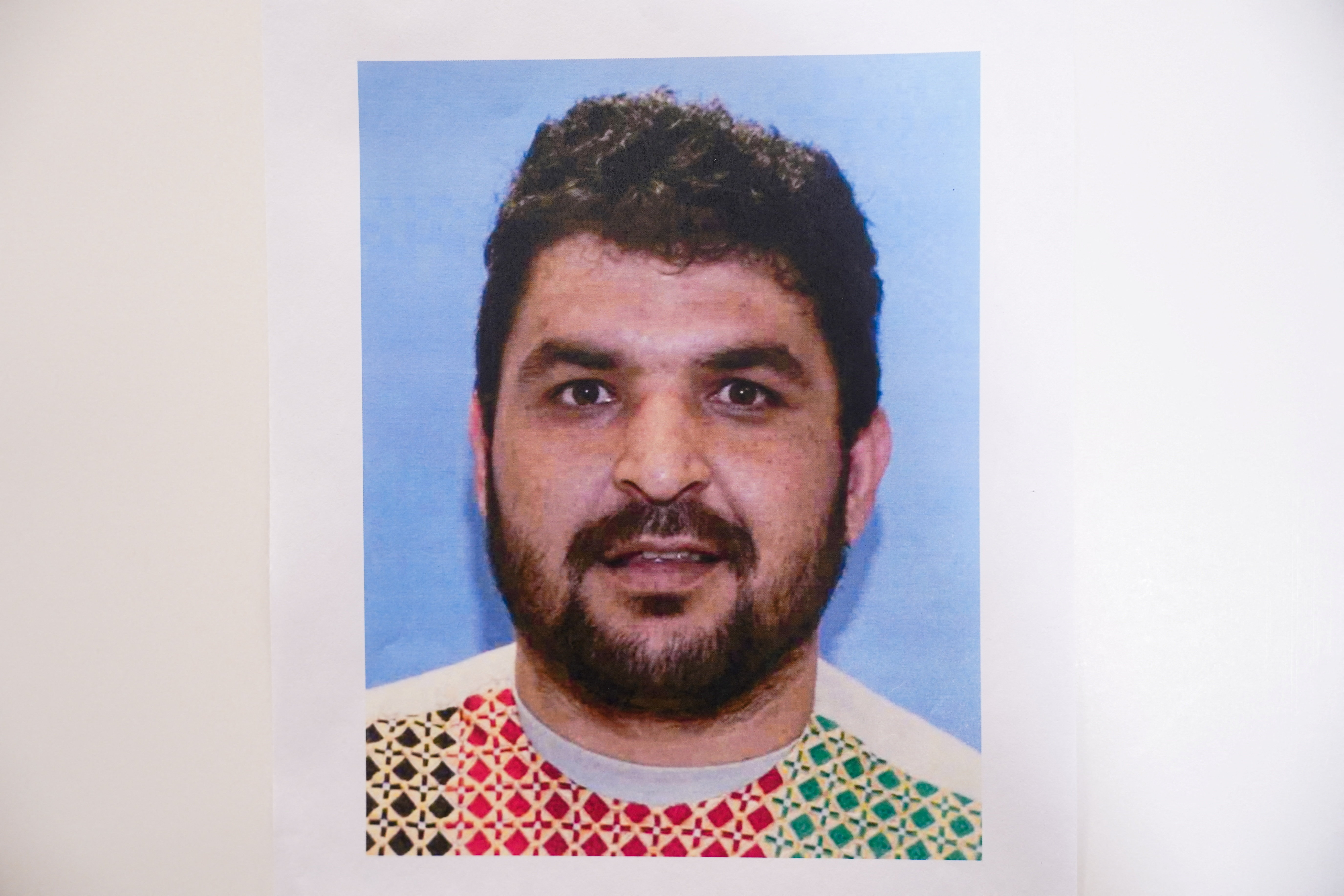 A picture of Rahmanullah Lakanwal, an Afghan national who is the suspect in the shooting of two National Guard members, is displayed at a press conference with FBI Director Kash Patel, attorney Jeanine Pirro and other authorities
