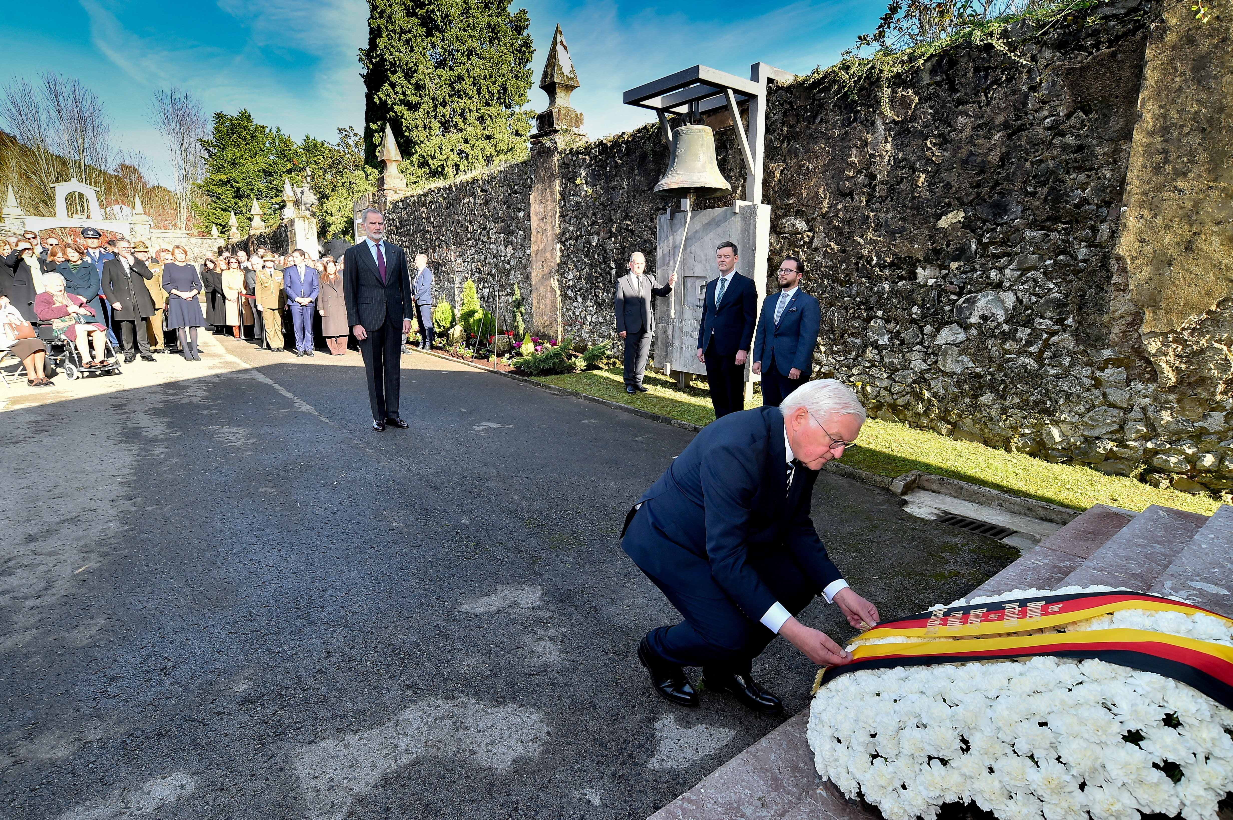 German President Frank-Walter Steinmeier adjusts a ribbon with the colours of the German flag on a flower wreath, as he and Spain's King Felipe attend a tribute to the victims of the Nazi bombing during the Spanish Civil War