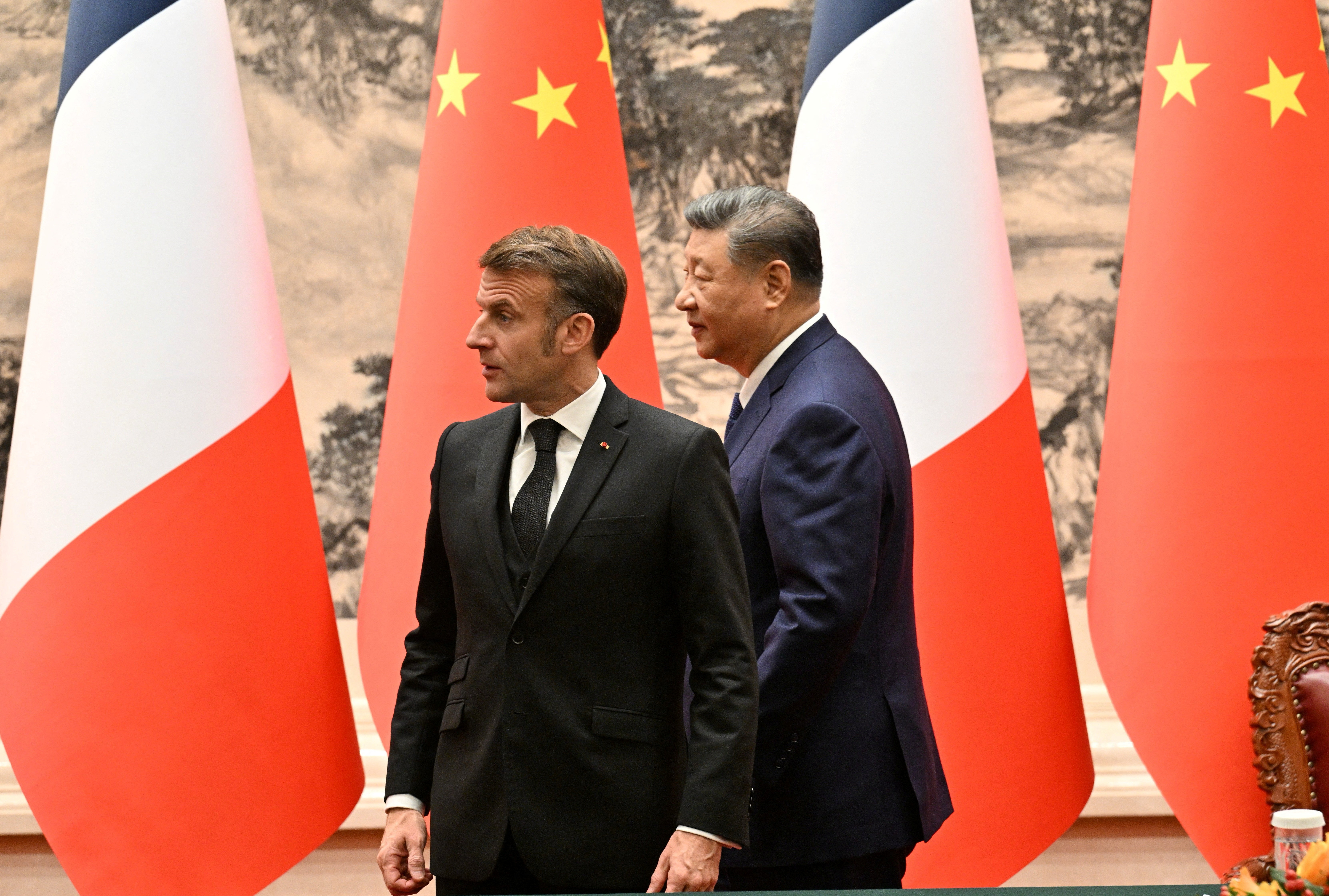 France’s President Emmanuel Macron (L) and China’s President Xi Jinping (R) walk.