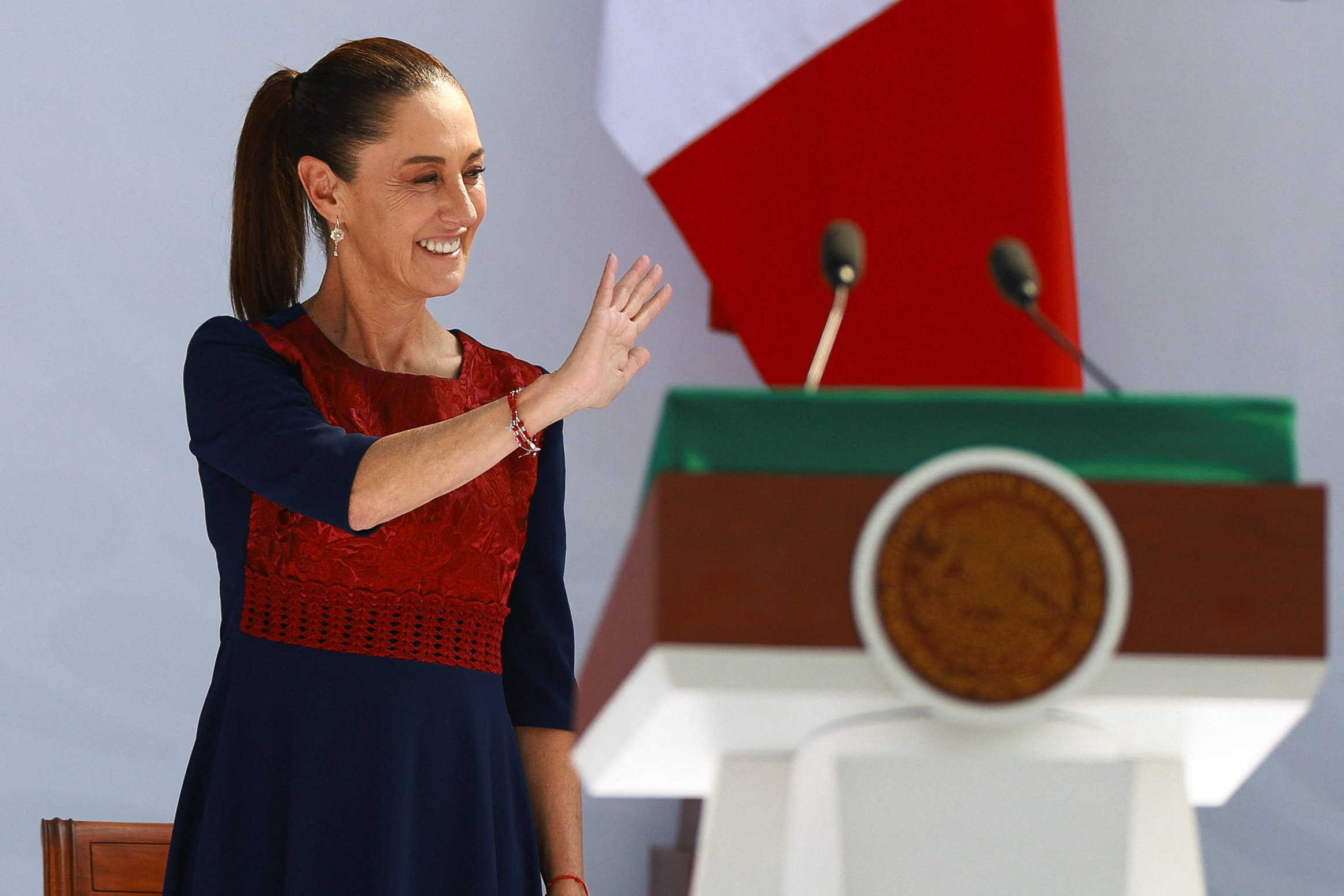 Mexico's President Claudia Sheinbaum waves during an event in Zocalo Square to commemorate 7 years since her party, Morena, came to power.