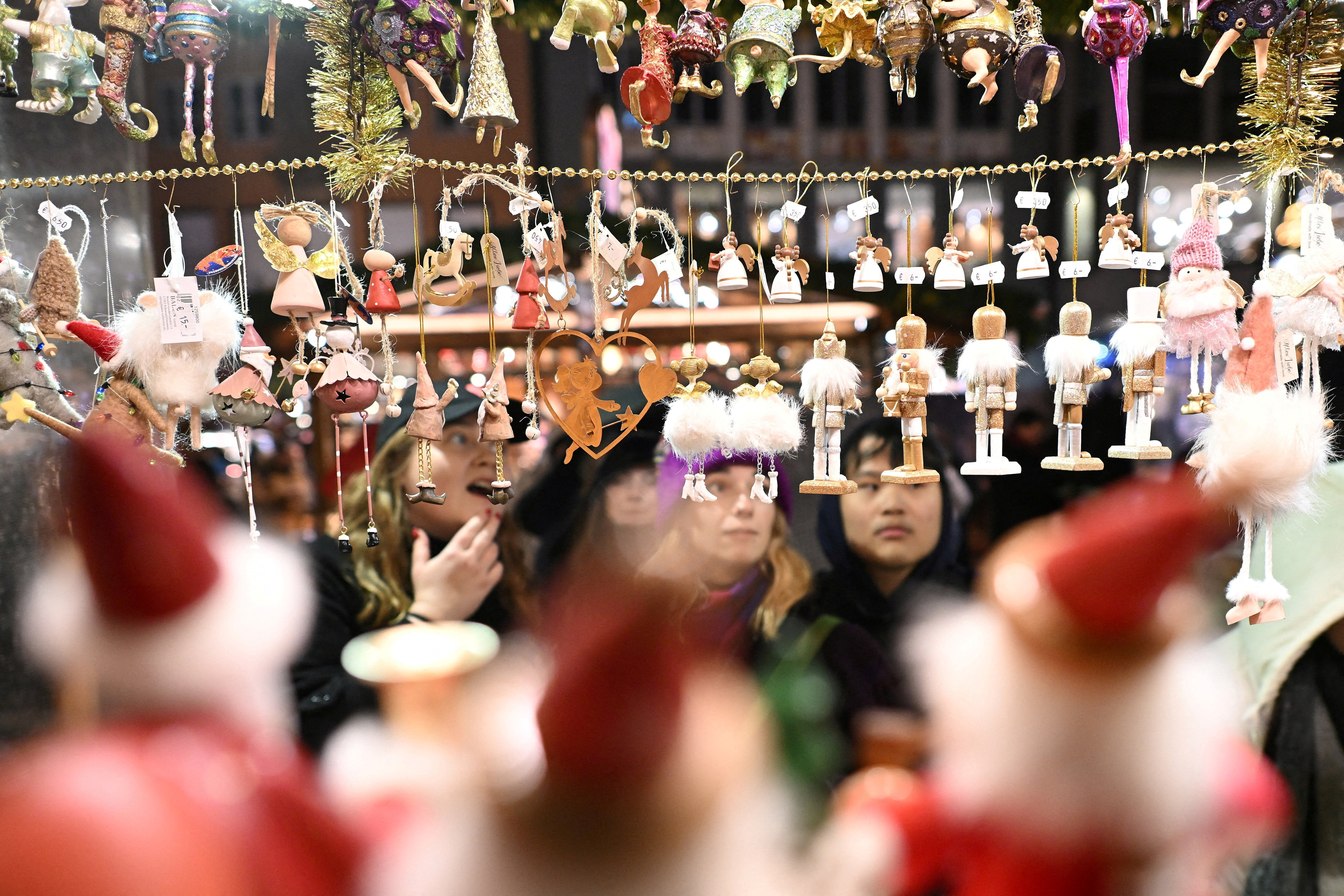 FILE PHOTO: Visitors look at merchandise during the opening day of the Marienplatz Christmas market in Munich, Germany, November 24, 2025. REUTERS/Angelika Warmuth/File Photo