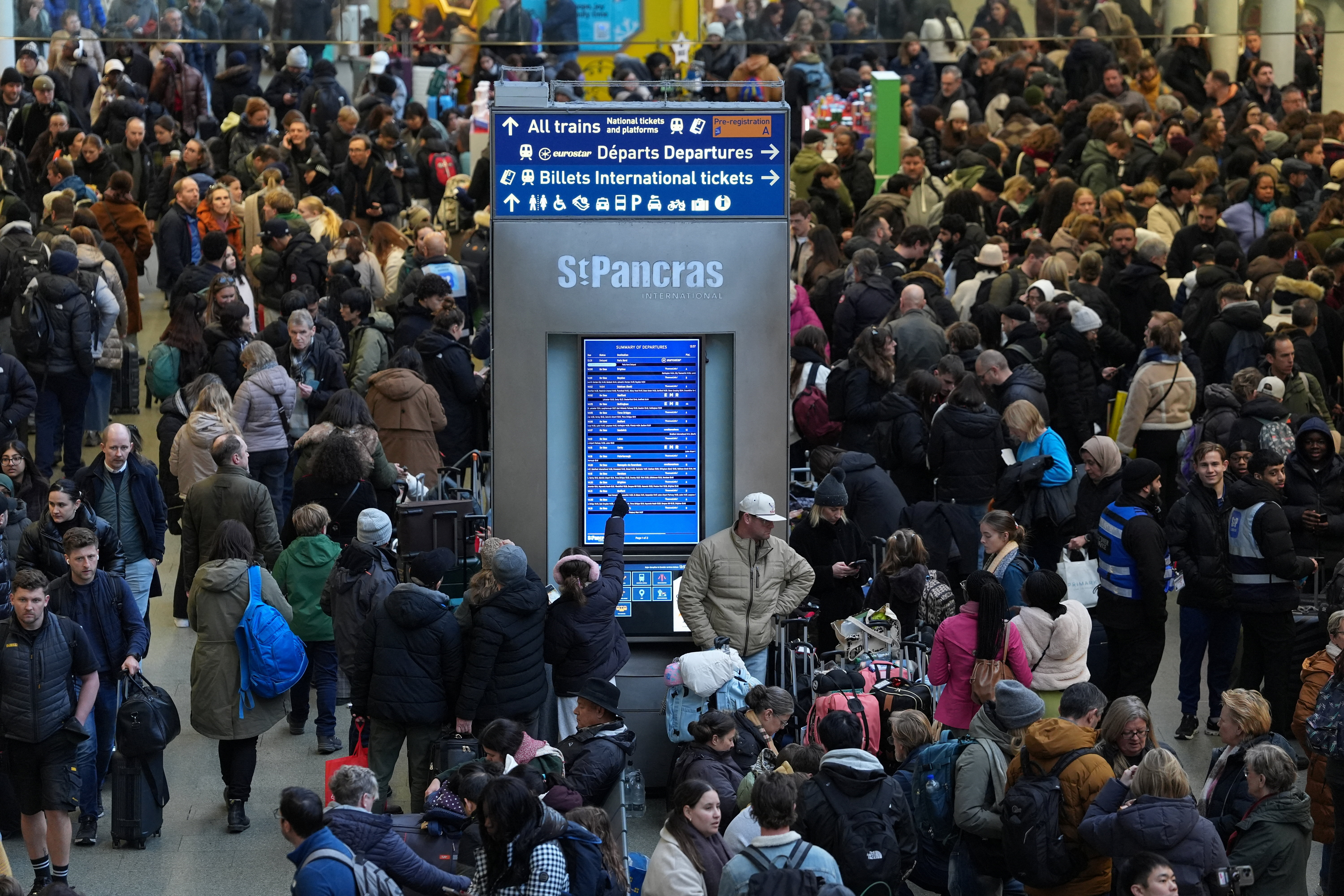 A person points to a departure board, after a Eurostar spokesperson said they were suspending its cross-Channel train services to and from London until further notice following a power supply problem in the Channel Tunnel that links Britain and France
