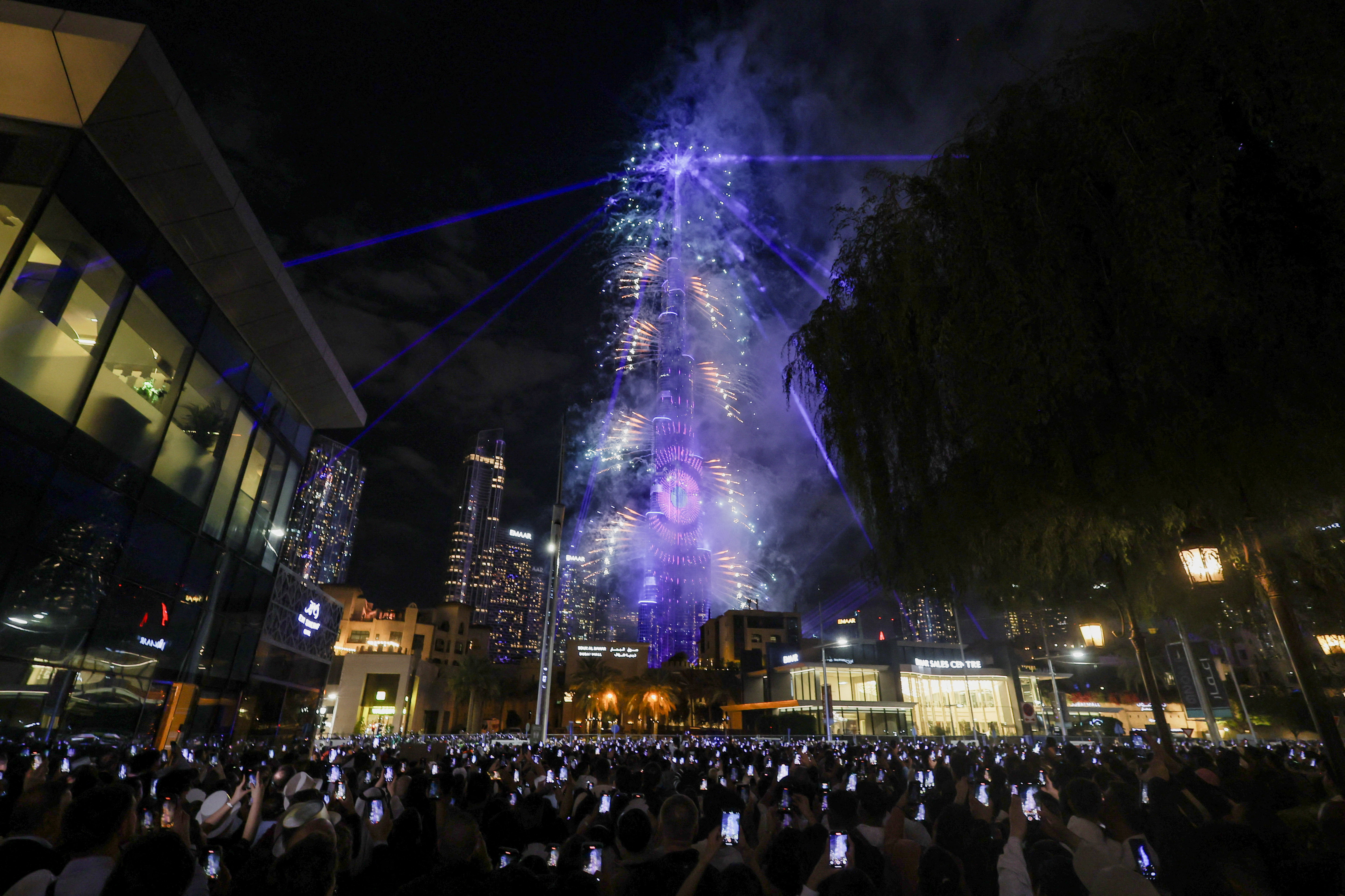 People hold their phones and watch fireworks near the Burj Khalifa during New Year's celebrations in Dubai, United Arab Emirates January 1, 2026. REUTERS/Amr Alfiky