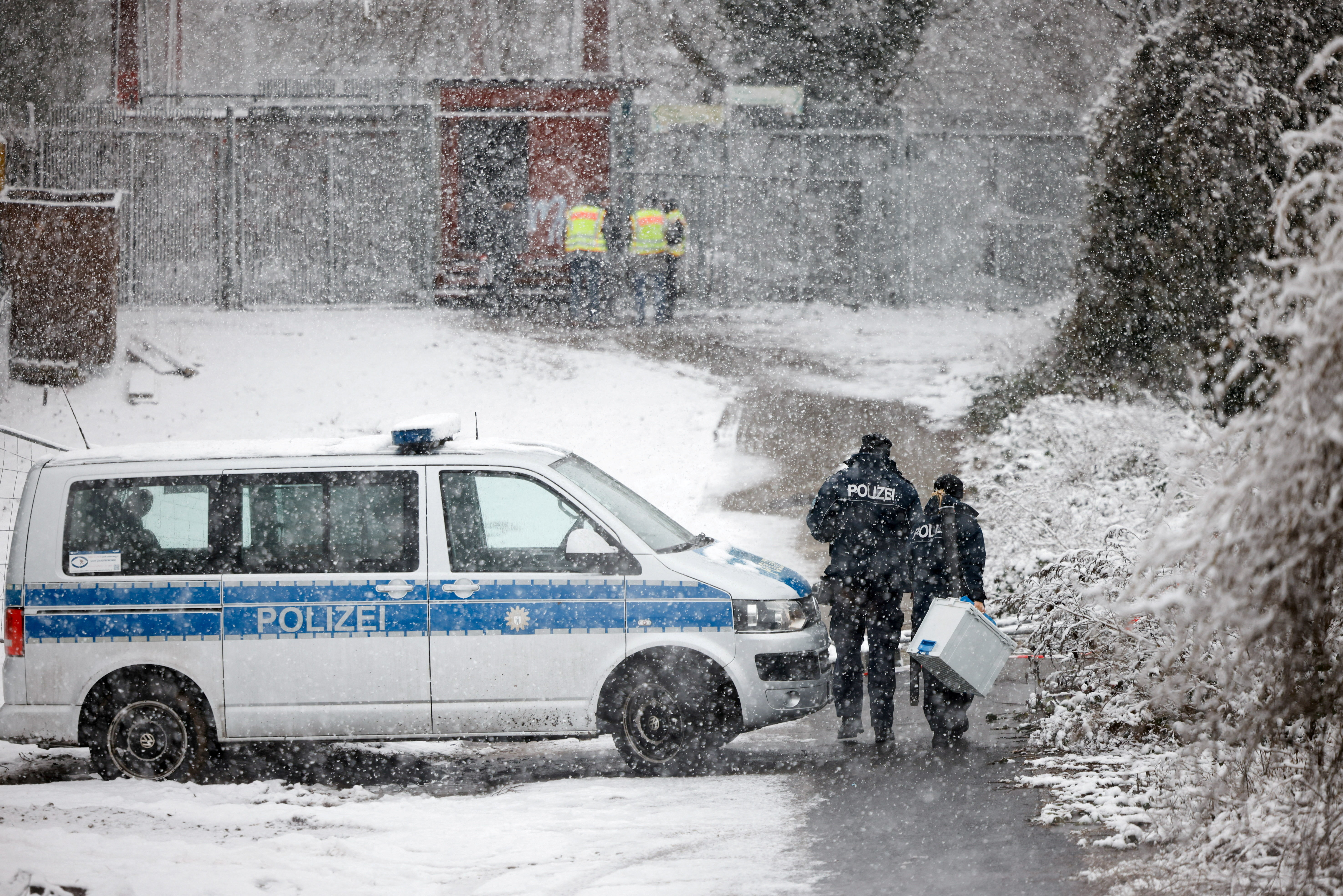 Police officers walk outside a power distribution system that caught fire, causing a blackout in parts of the city, in Berlin, Germany, January 3, 2026.  REUTERS/Axel Schmidt