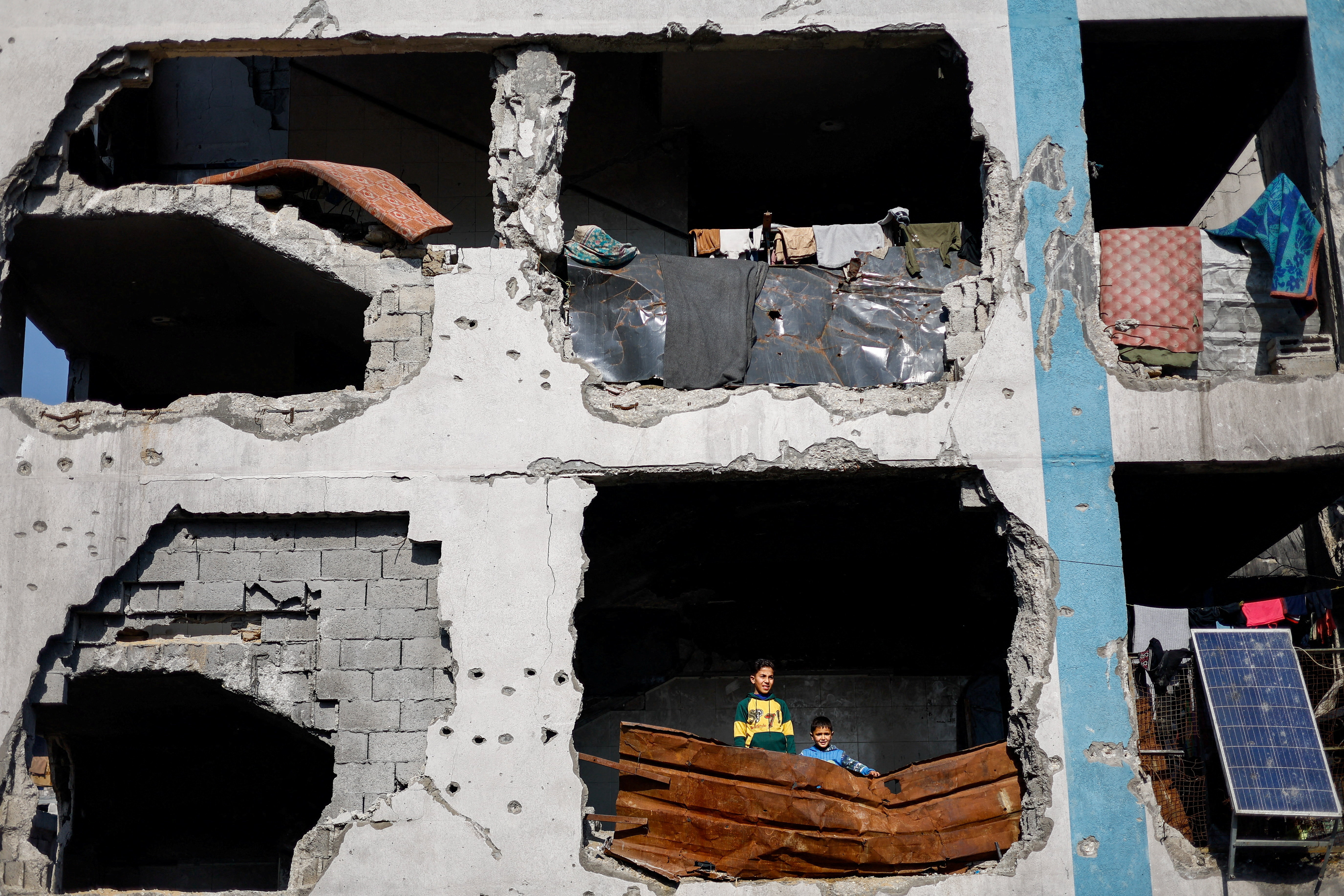 Palestinians look out from a building destroyed during the war, in Jabalia, northern Gaza Strip, January 6, 2026.      TPX IMAGES OF THE DAY