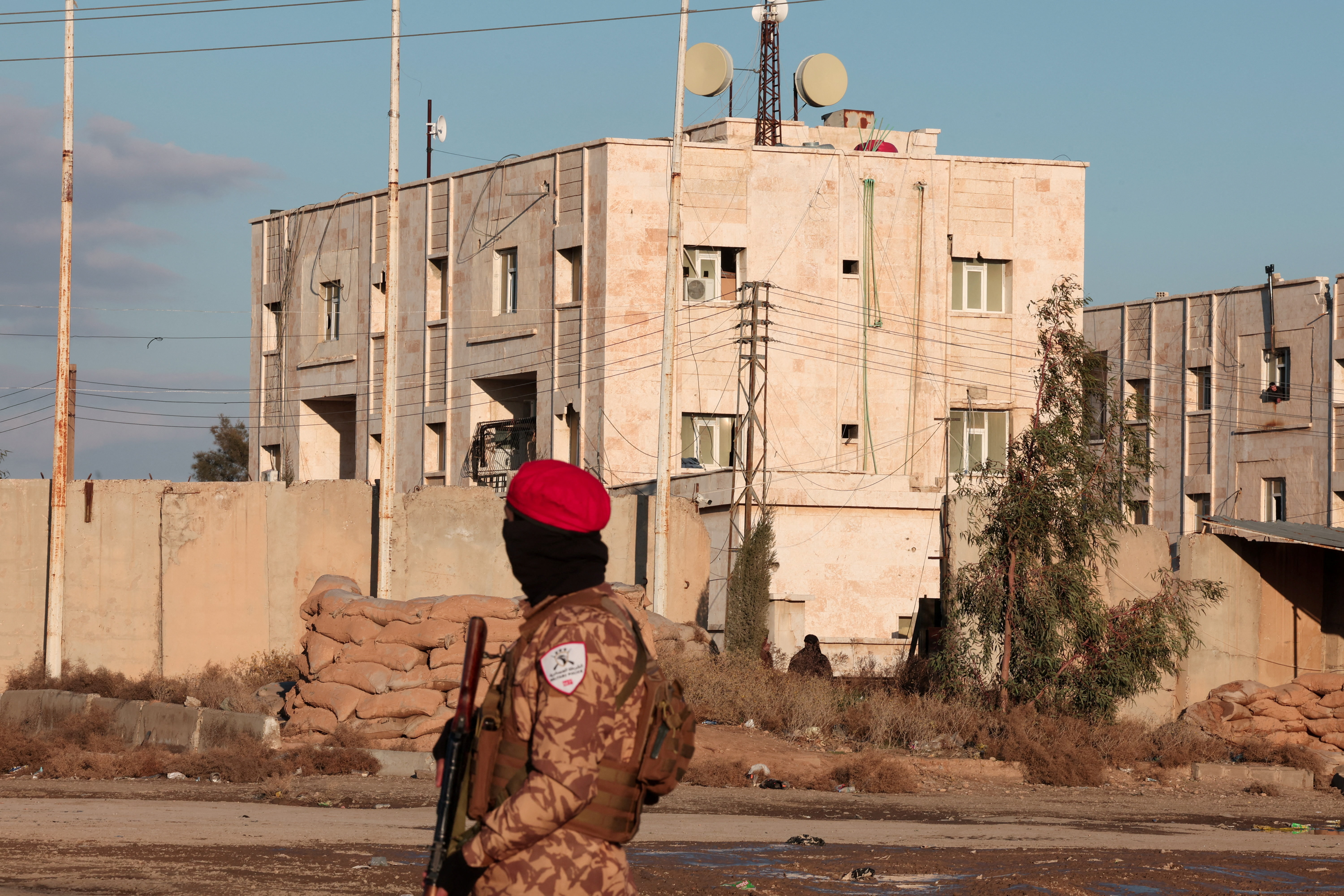 A member of Syrian military police stands guard near Raqqa prison, where the Syrian army is besieging SDF members after the army took control of the city of Raqqa, Syria