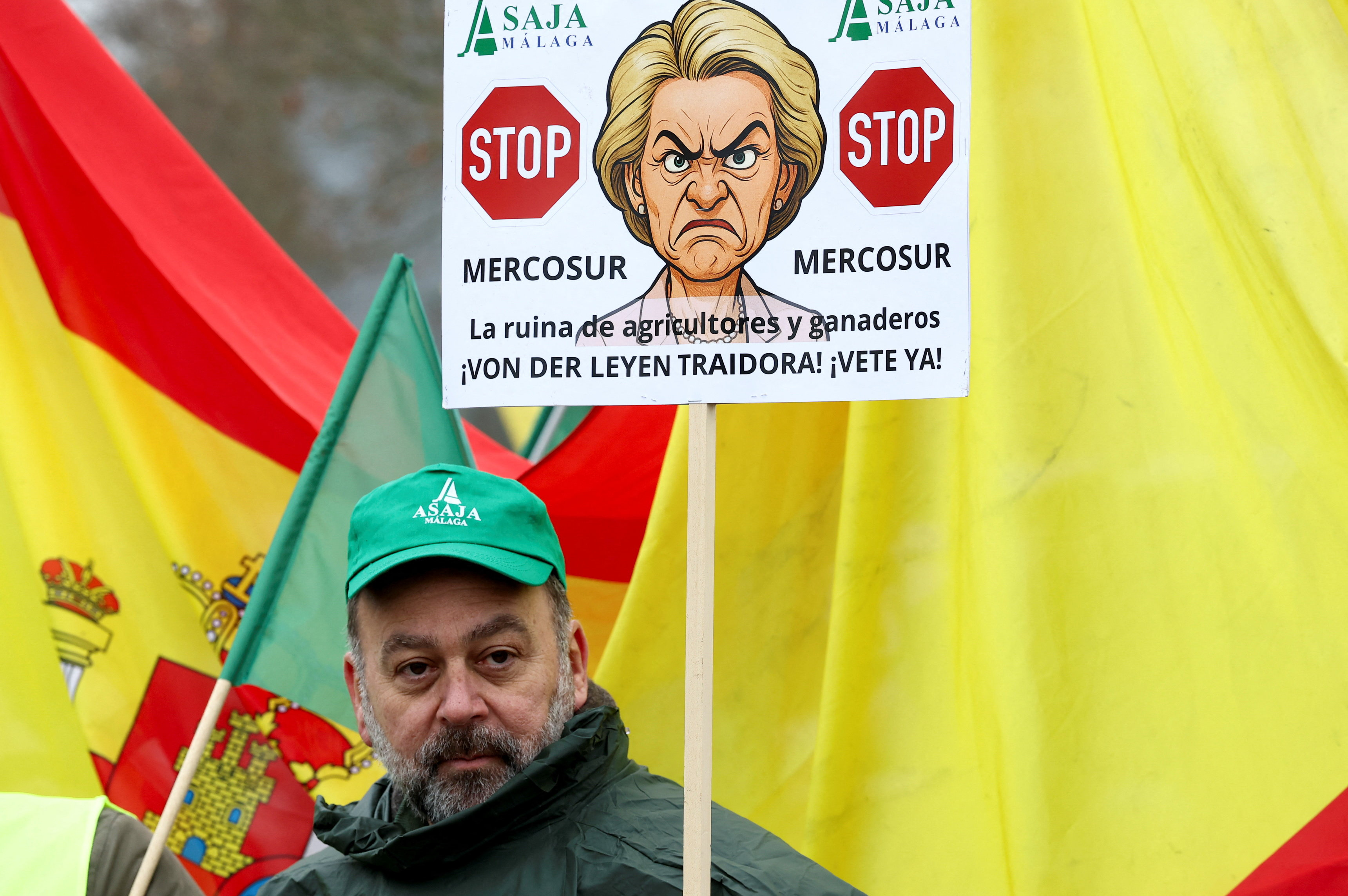 A protester holds a placard with a caricature of European Commission President Ursula von der Leyen outside the European Parliament REUTERS/Yves Herman