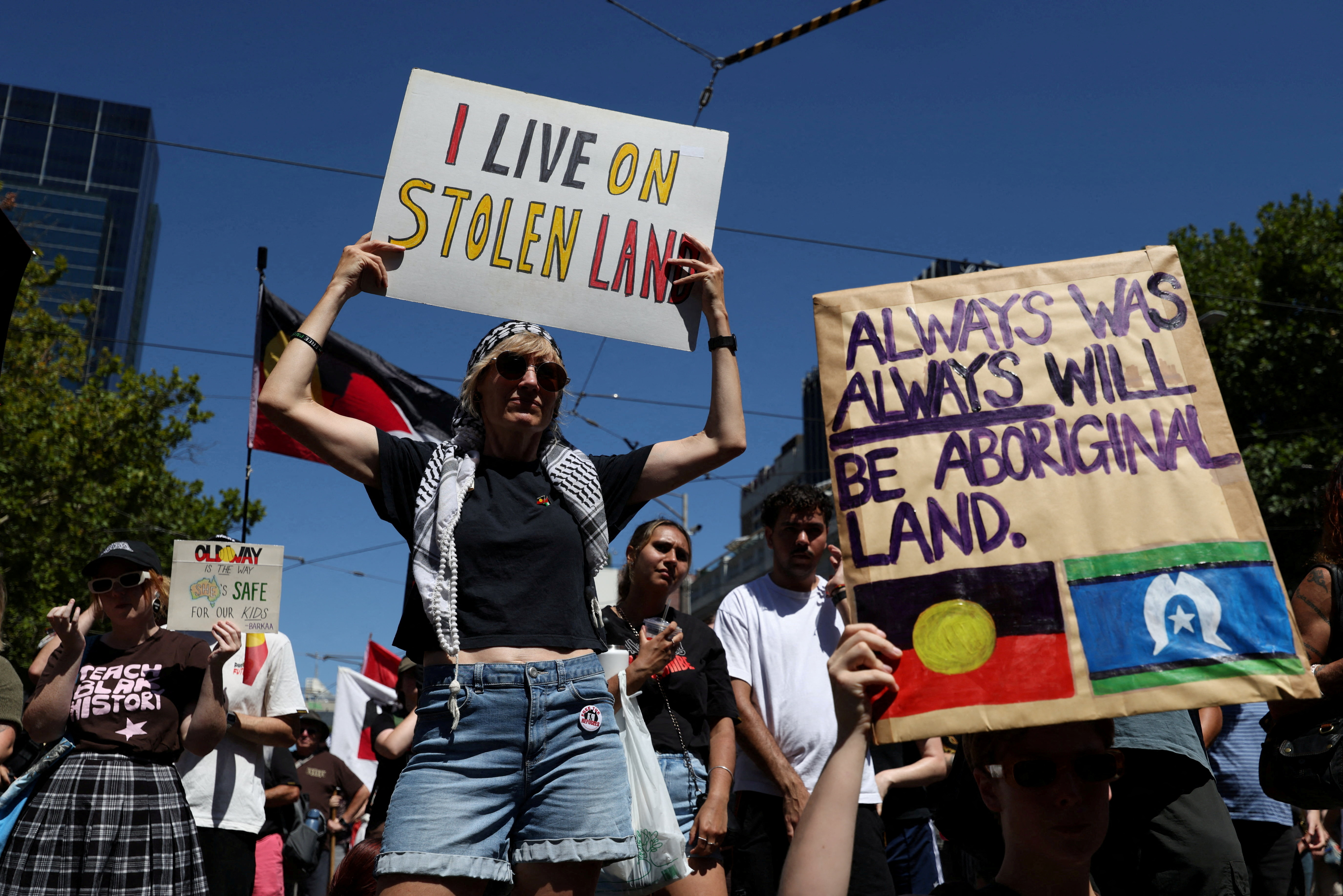 FILE PHOTO: Protestors hold signs as they gather for an "Invasion Day" rally on Australia's national day, Australia Day, in Melbourne, Australia January 26, 2026.