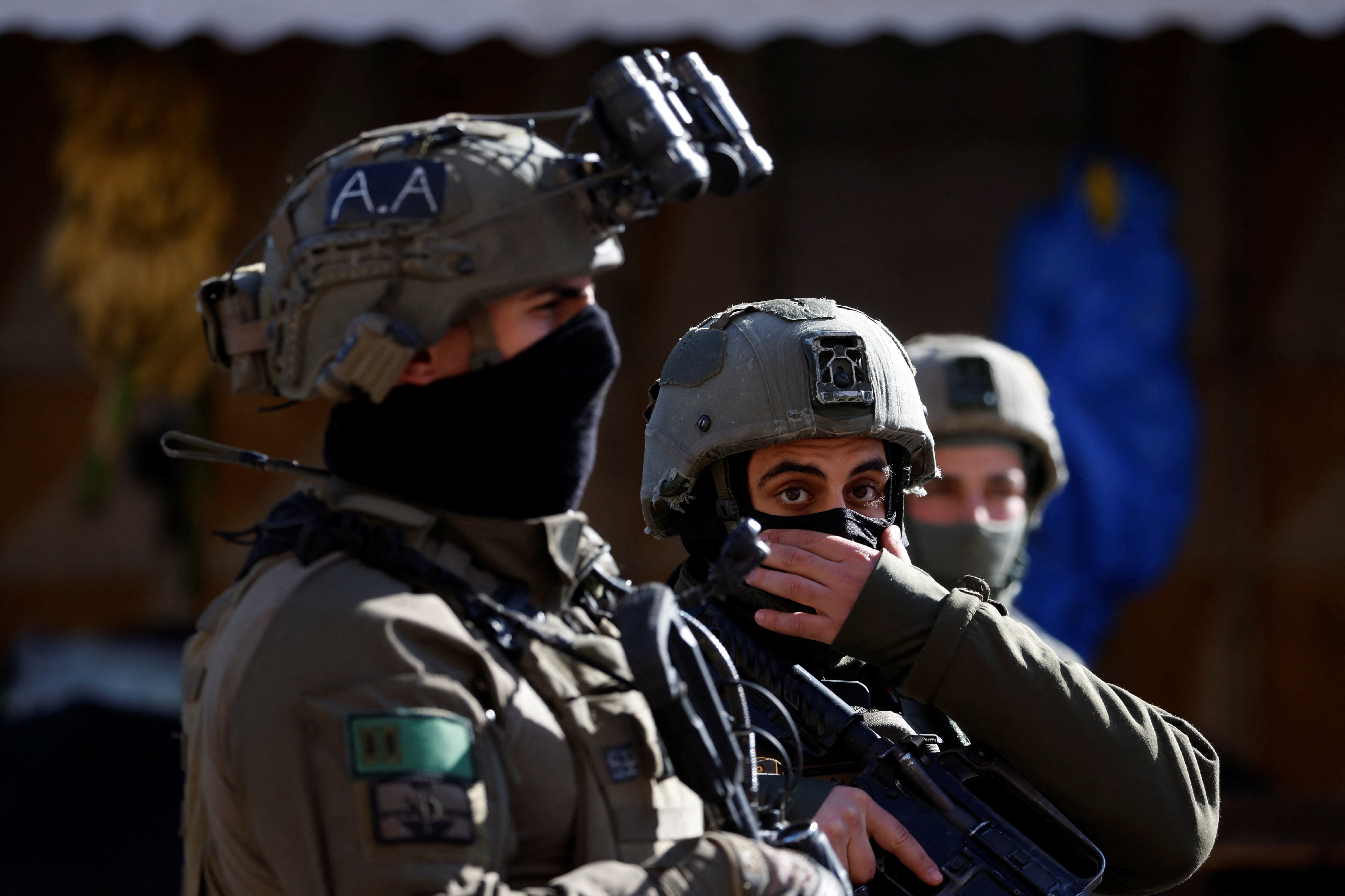 Israeli army soldiers take position during an Israeli multi-day raid in Hebron in the Israeli-occupied West Bank
