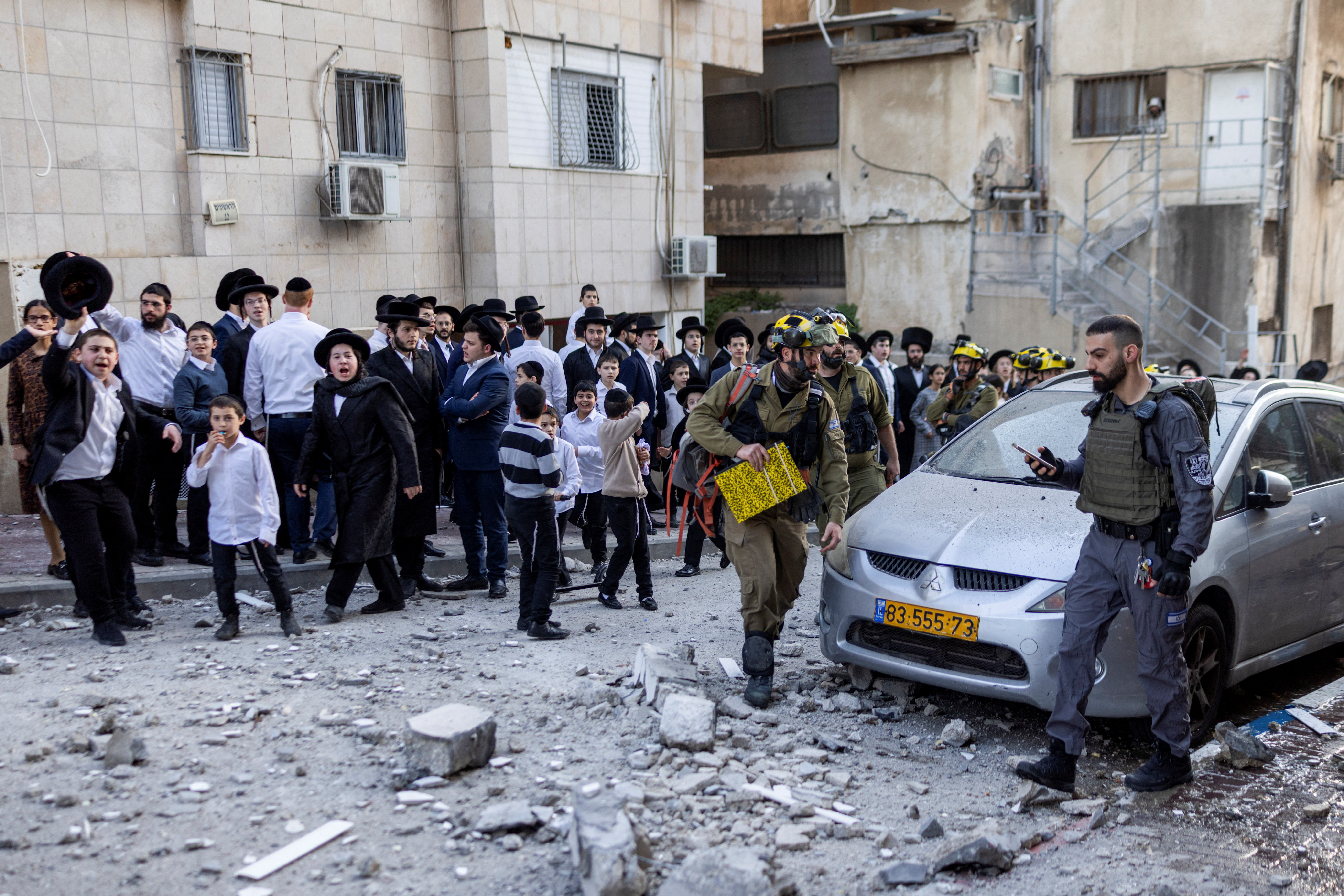 Ultra-Orthodox Jewish Israelis gather at the scene where damage was caused by missiles launched towards Israel from Iran following strikes by Israel and the U.S. on Iran, in Bnei Brak, Israel February 28, 2026.