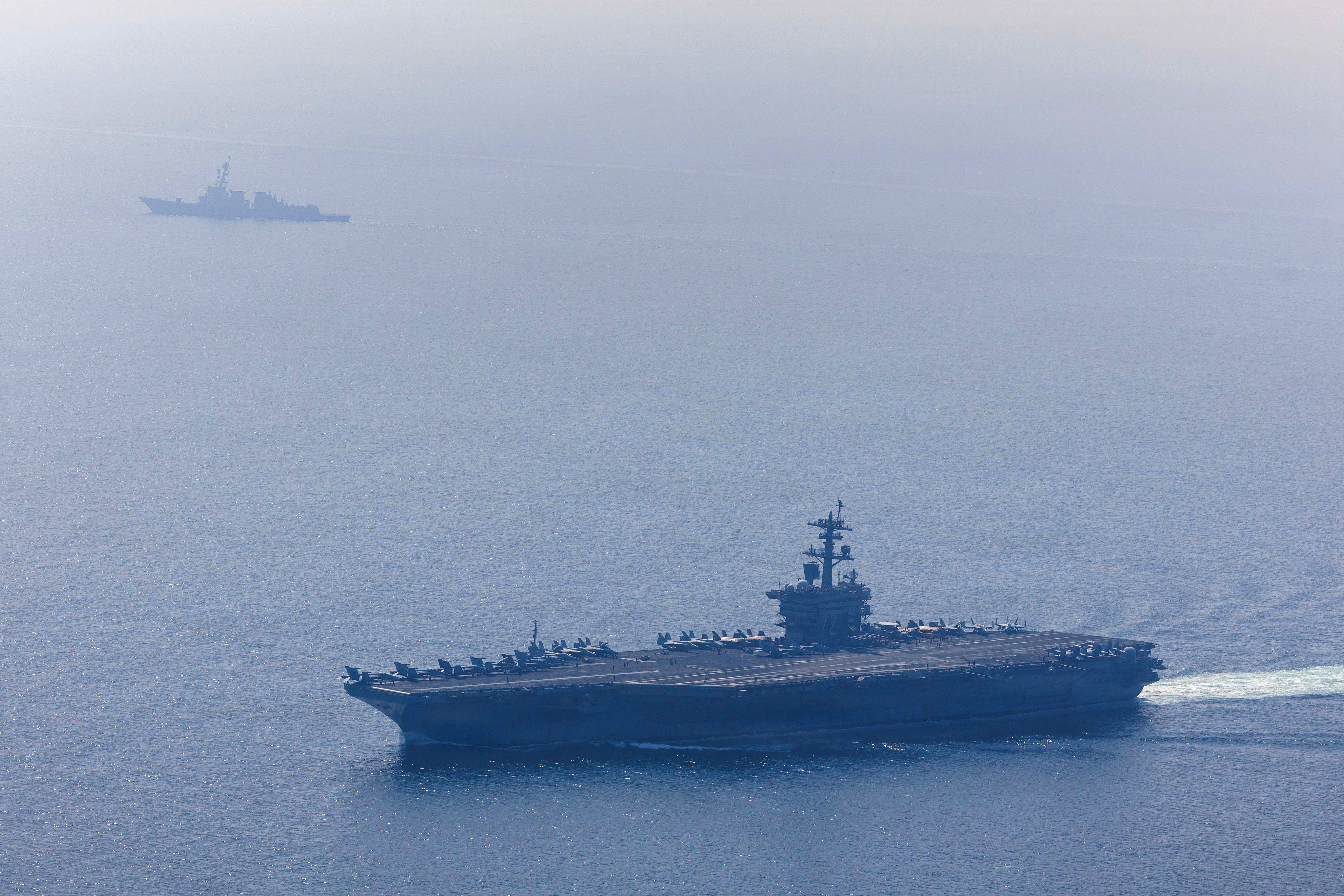 The U.S. Navy's Nimitz-class aircraft carrier USS Abraham Lincoln and Arleigh Burke-class guided-missile destroyer USS Frank E. Petersen Jr. sail