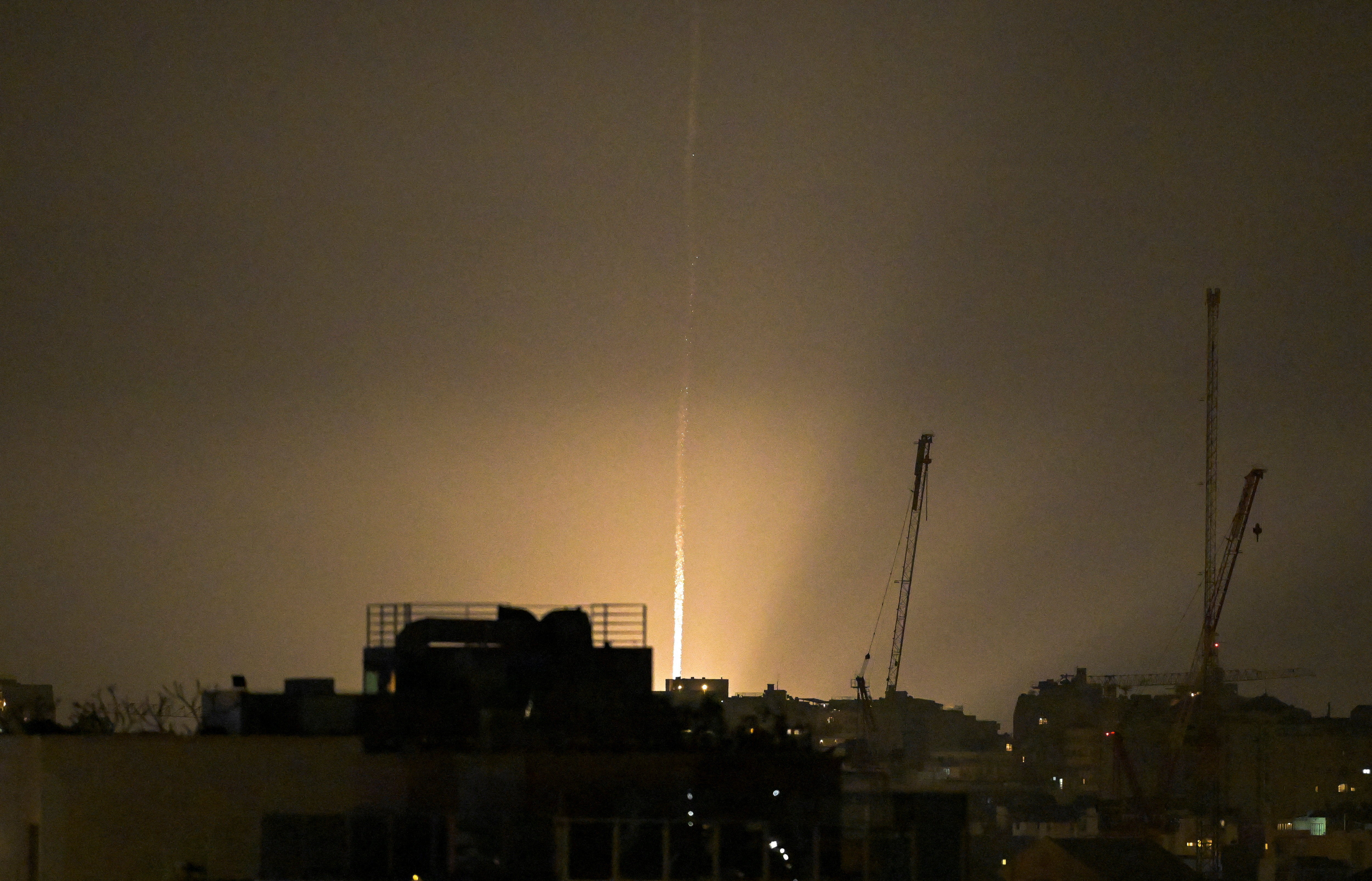 The sky is illuminated as an Iranian missile lands in Israel, amid the U.S.-Israeli conflict with Iran, as seen from Tel Aviv, Israel, March 12, 2026.