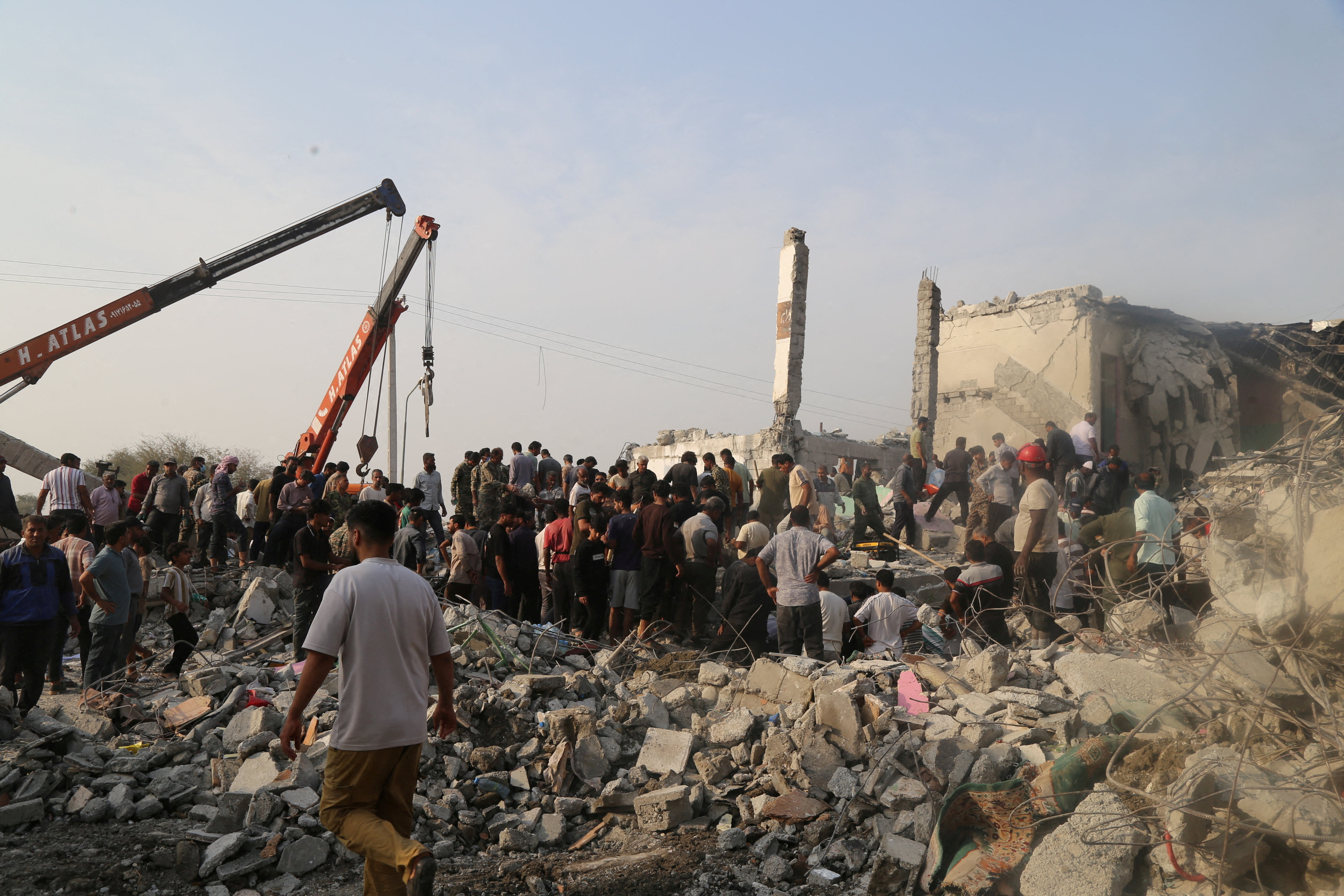 People and rescue forces work following a reported strike on a school in Minab, Iran, February 28, 2026.