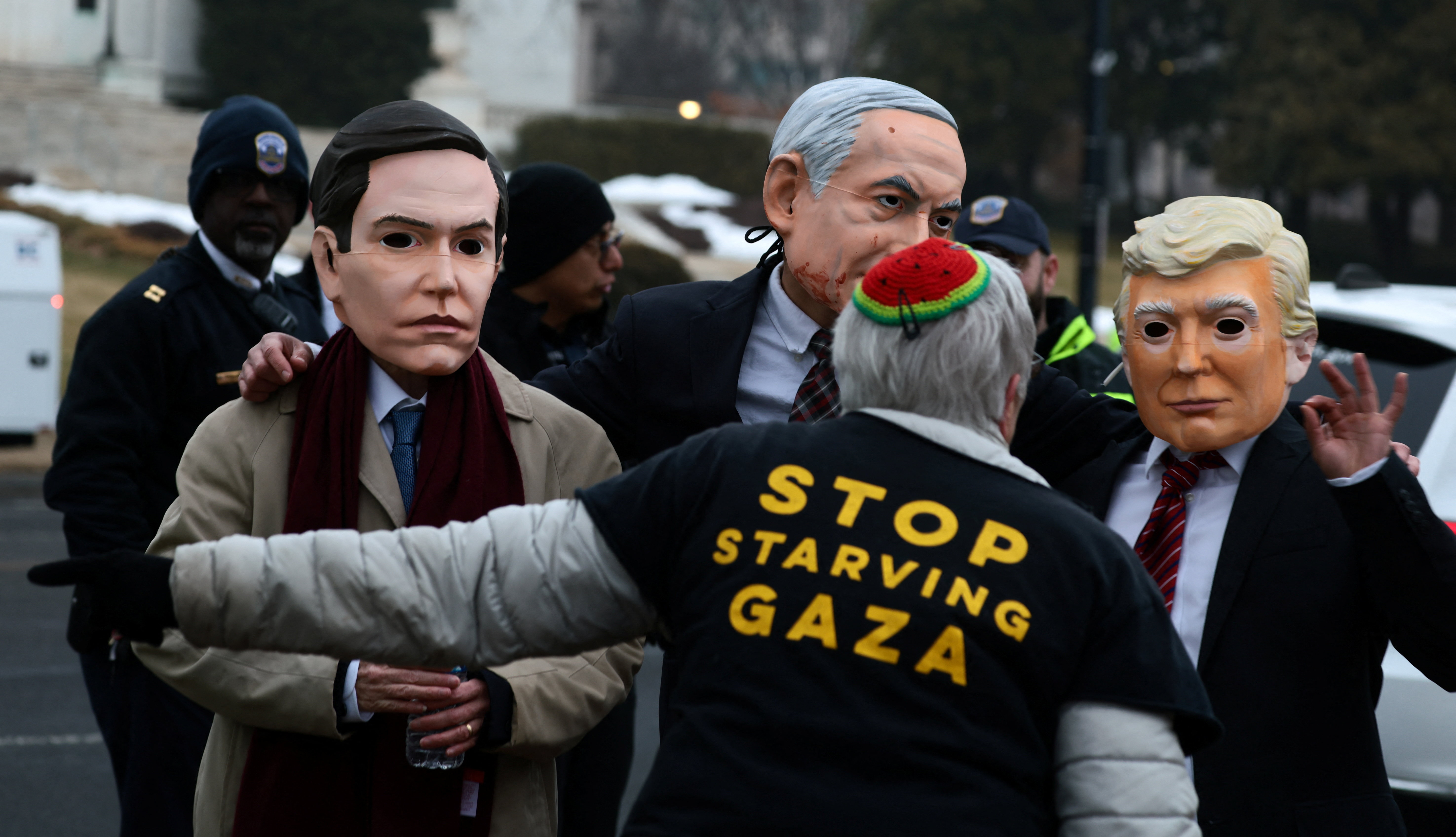 Demonstrators wearing masks depicting U.S. Secretary of State Marco Rubio, Israeli Prime Minister Benjamin Netanyahu, and U.S. President Donald Trump take part in a protest near U.S. Institute of Peace building