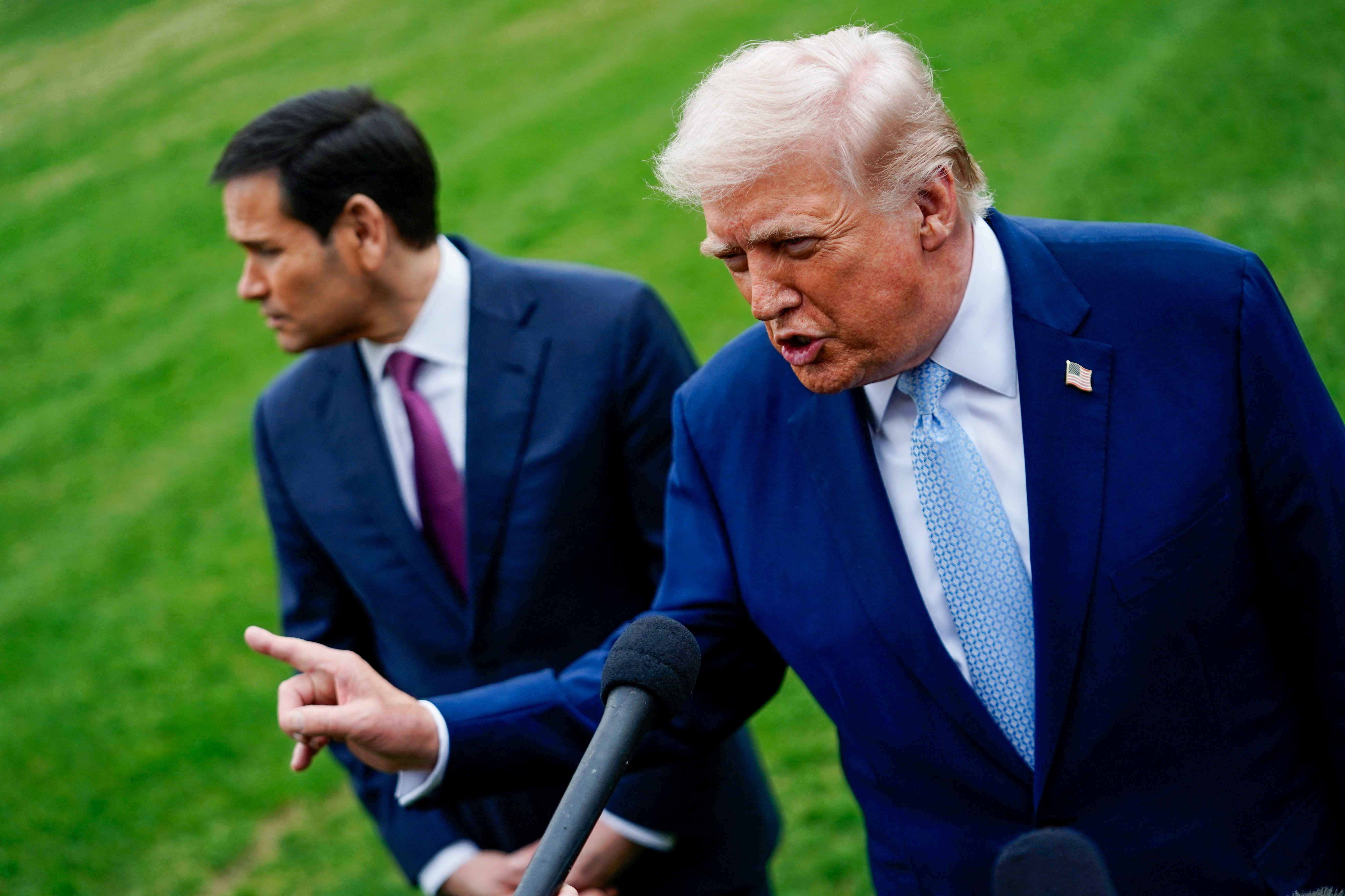 U.S. President Donald Trump speaks to the media, flanked by U.S. Secretary of State Marco Rubio, as he departs the White House for Florida, in Washington, D.C., U.S., March 20, 2026. REUTERS/Nathan Howard