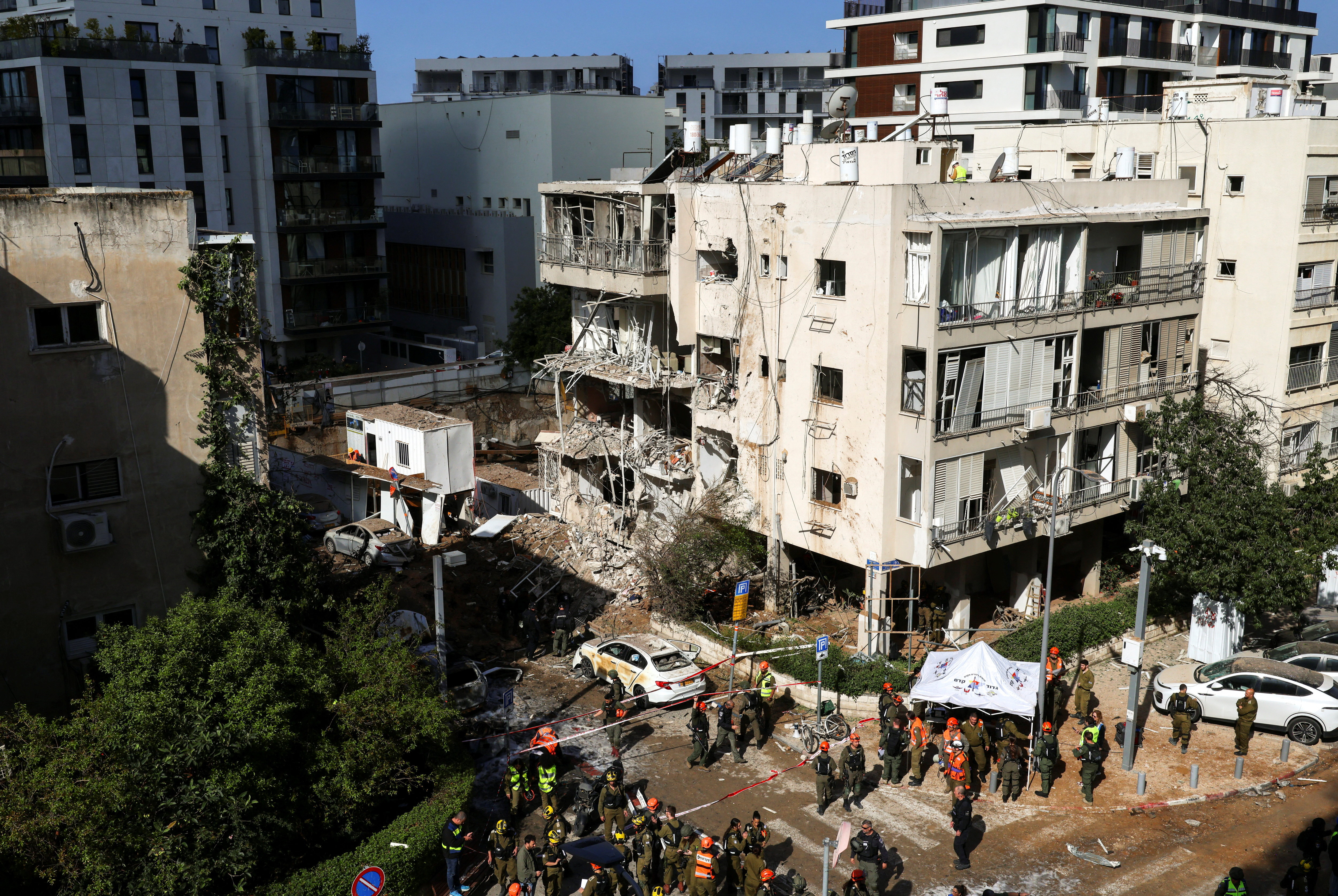 Emergency personnel work at the site following Iranian missile barrages in central Israel, amid the U.S.-Israel conflict with Iran, in Tel Aviv, Israel, March 24, 2026.