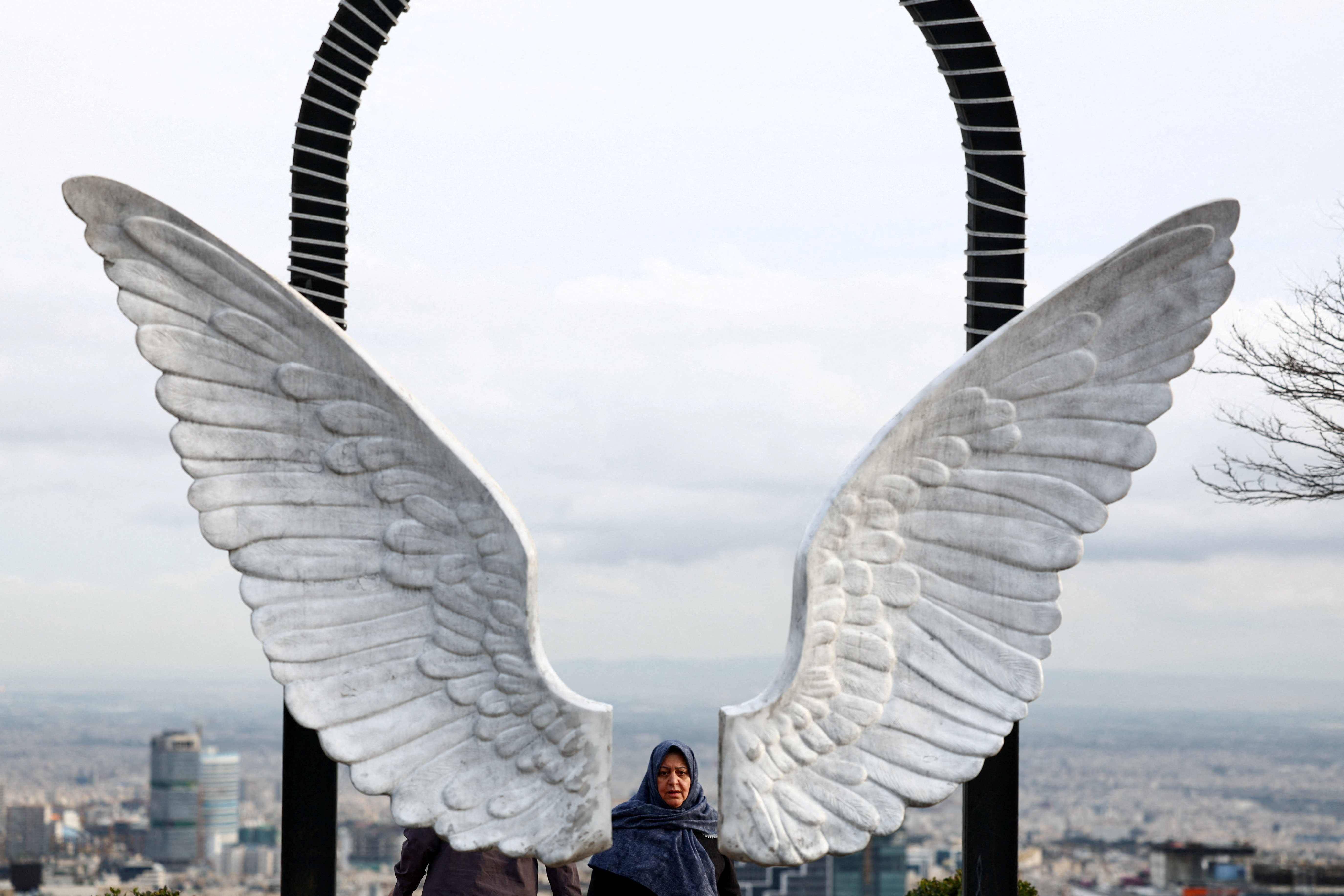 An Iranian woman walks at a park, amid the U.S.-Israeli conflict with Iran, in Tehran, Iran, March 25, 2026.