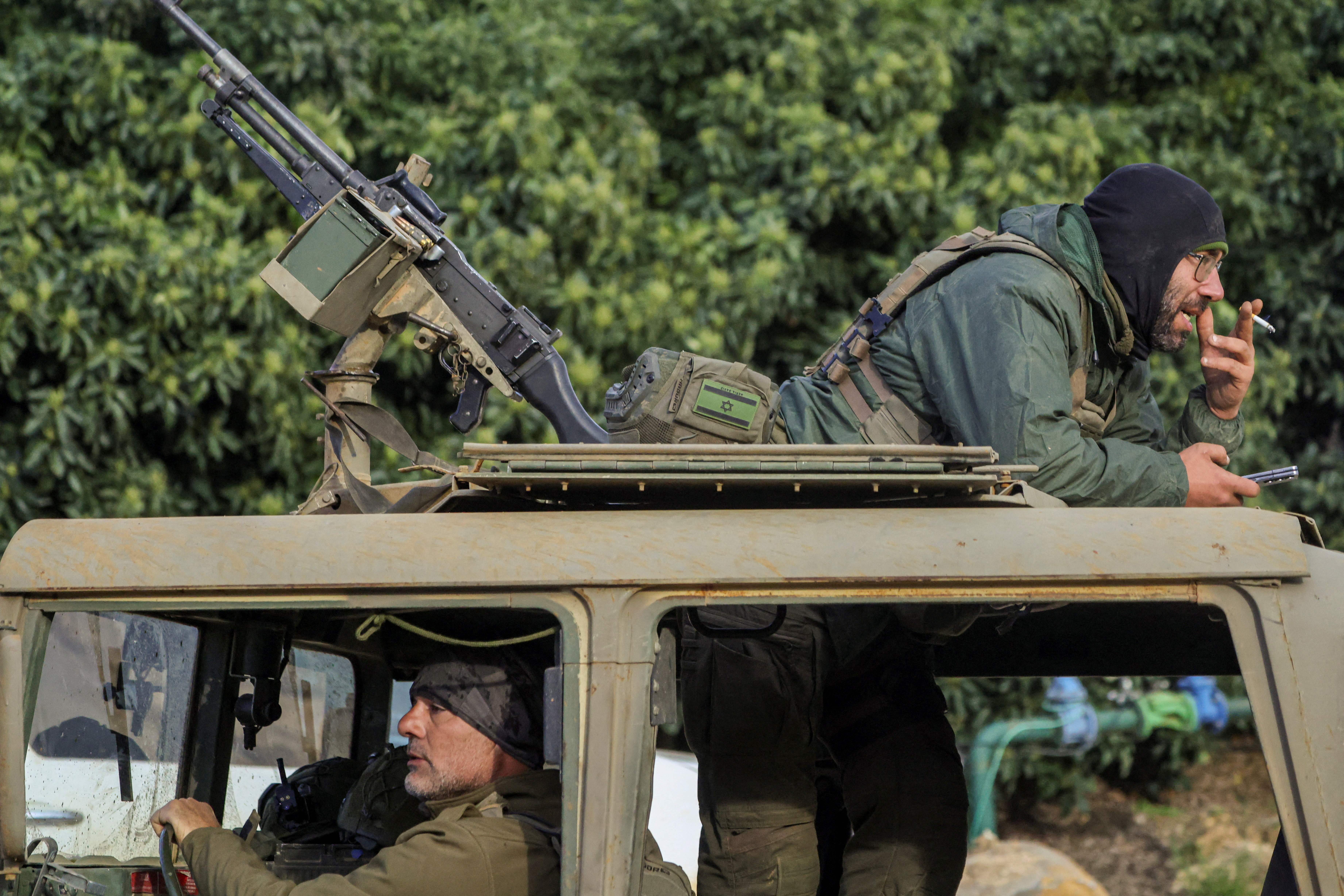 Israeli soldiers sit in a military jeep near the Israeli side of the border with Lebanon, amid escalating hostilities between Israel and Hezbollah, as the U.S.-Israeli conflict with Iran continues, in northern Israel, March 25, 2026.
