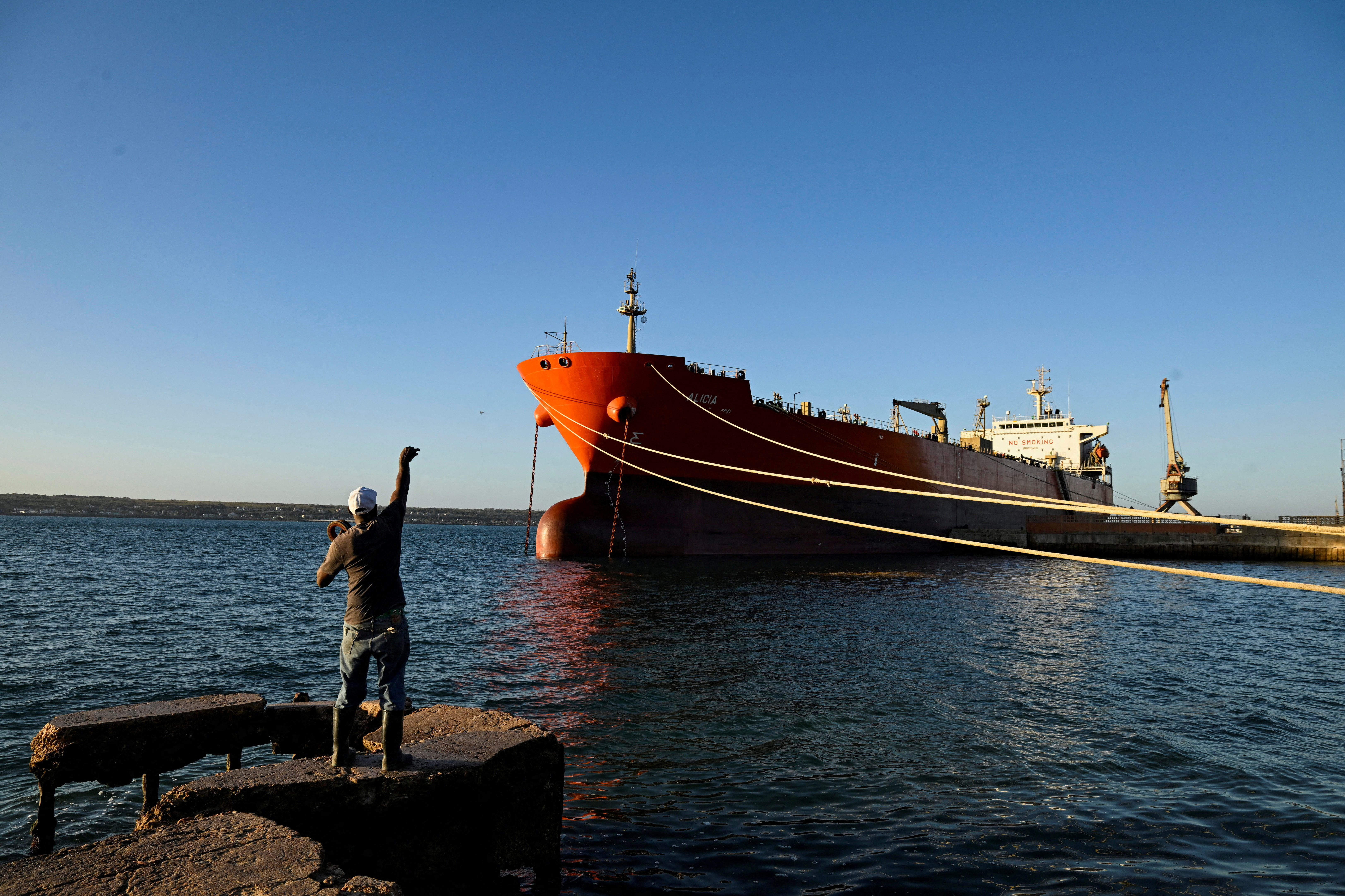 A man fishes near the Cuban-flagged tanker Alicia. REUTERS/Norlys Perez/File Photo