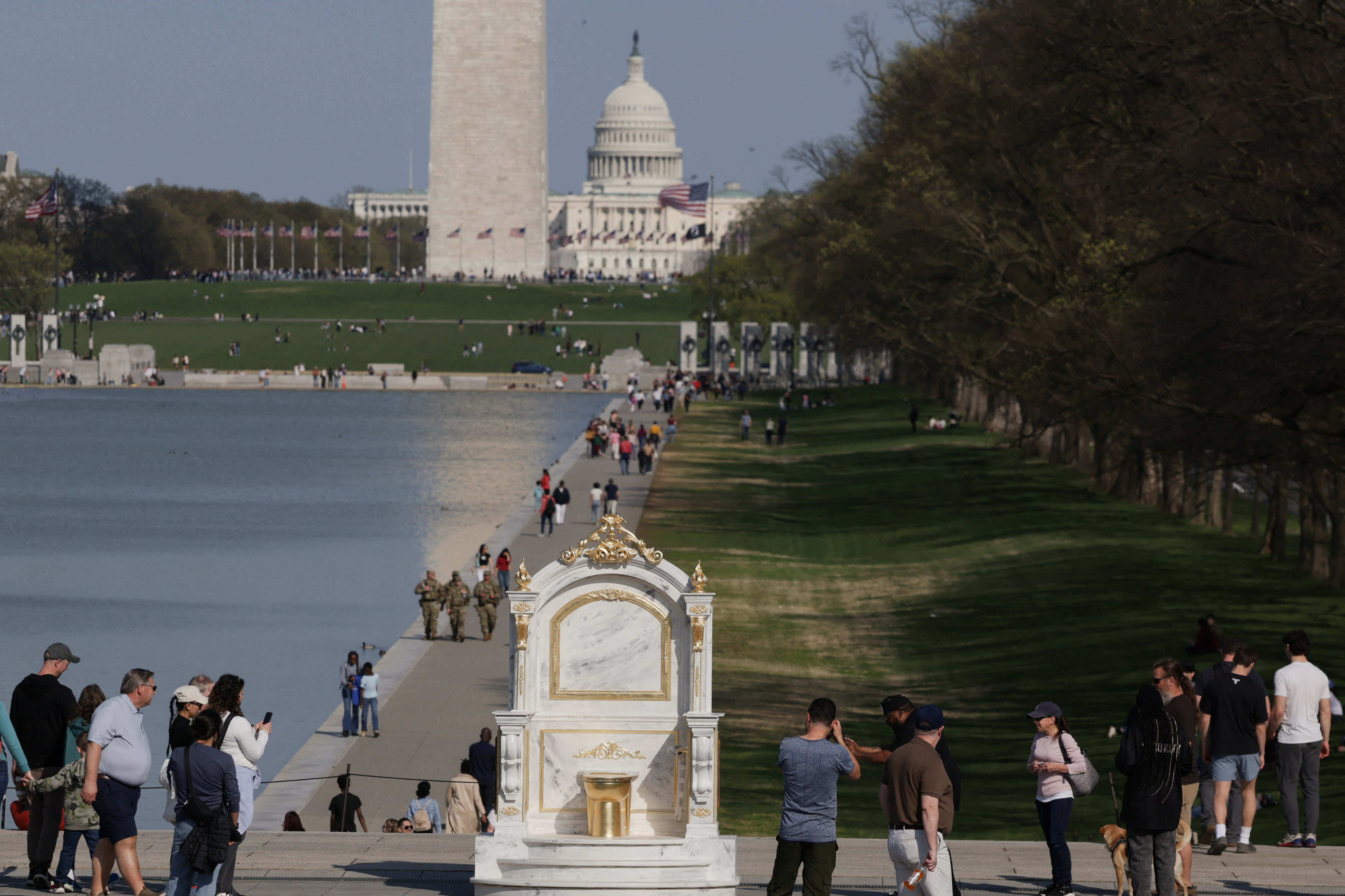 A statue featuring a large golden toilet, titled "A Throne Fit for a King," is displayed near the Lincoln Memorial on the National Mall in Washington, D.C., U.S., March 30, 2026.