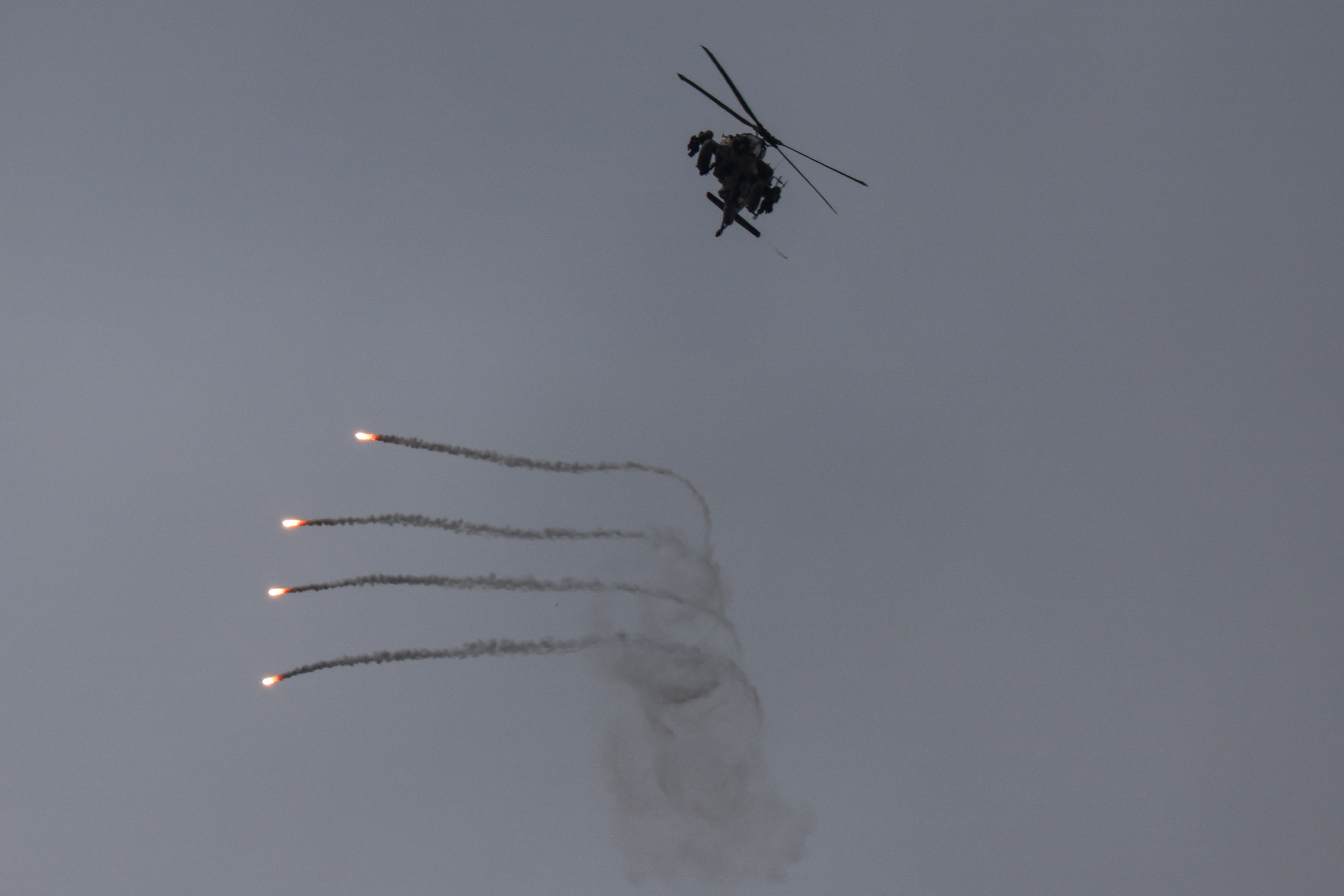An Israeli helicopter releases flares, near the Israel-Lebanon border, as seen from the Israeli side of the border in northern Israel