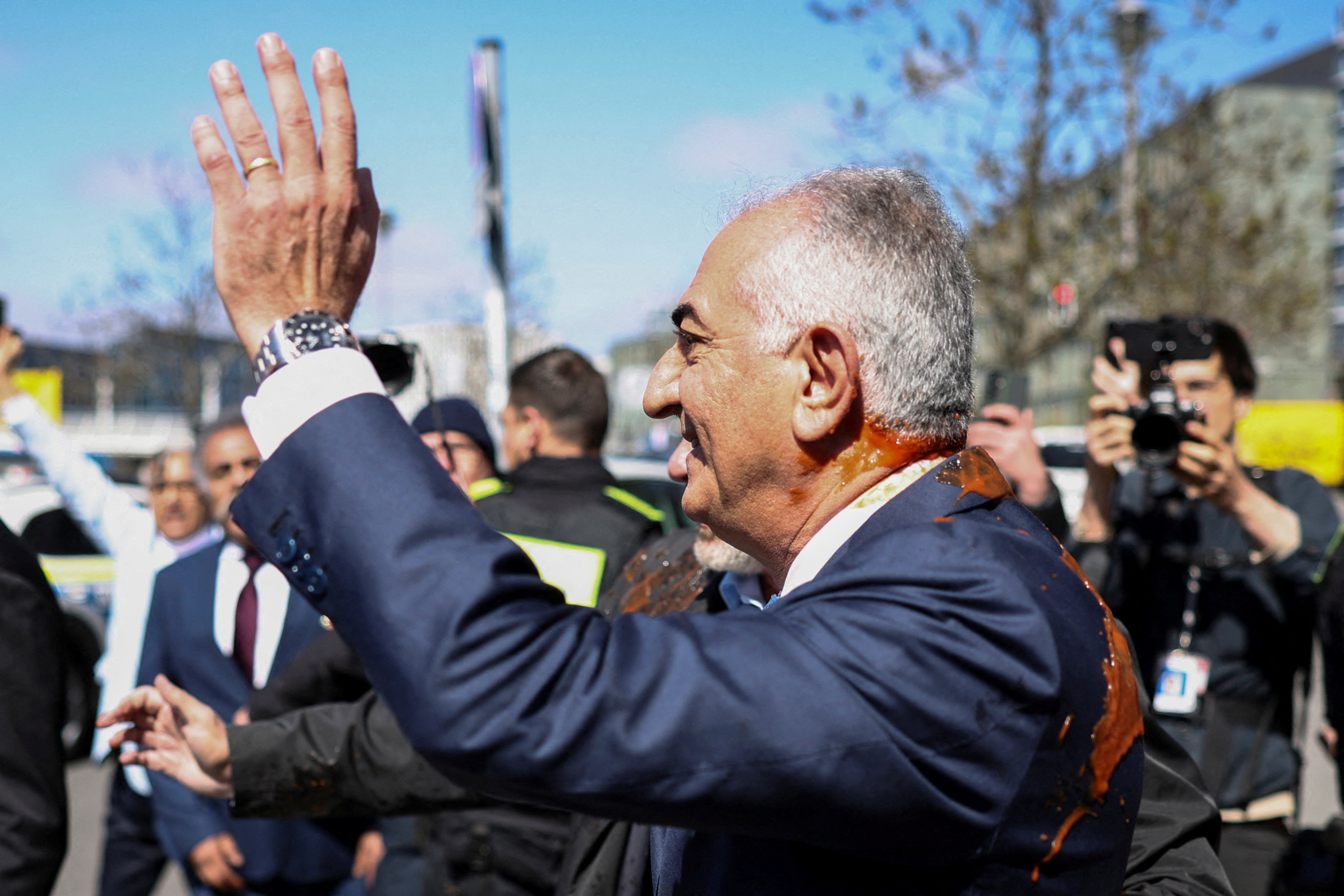Reza Pahlavi, the exiled son of Iran's last shah and an Iranian opposition figure, stained with red substance, leaves after a press conference at the House of the Bundespressekonferenz in Berlin