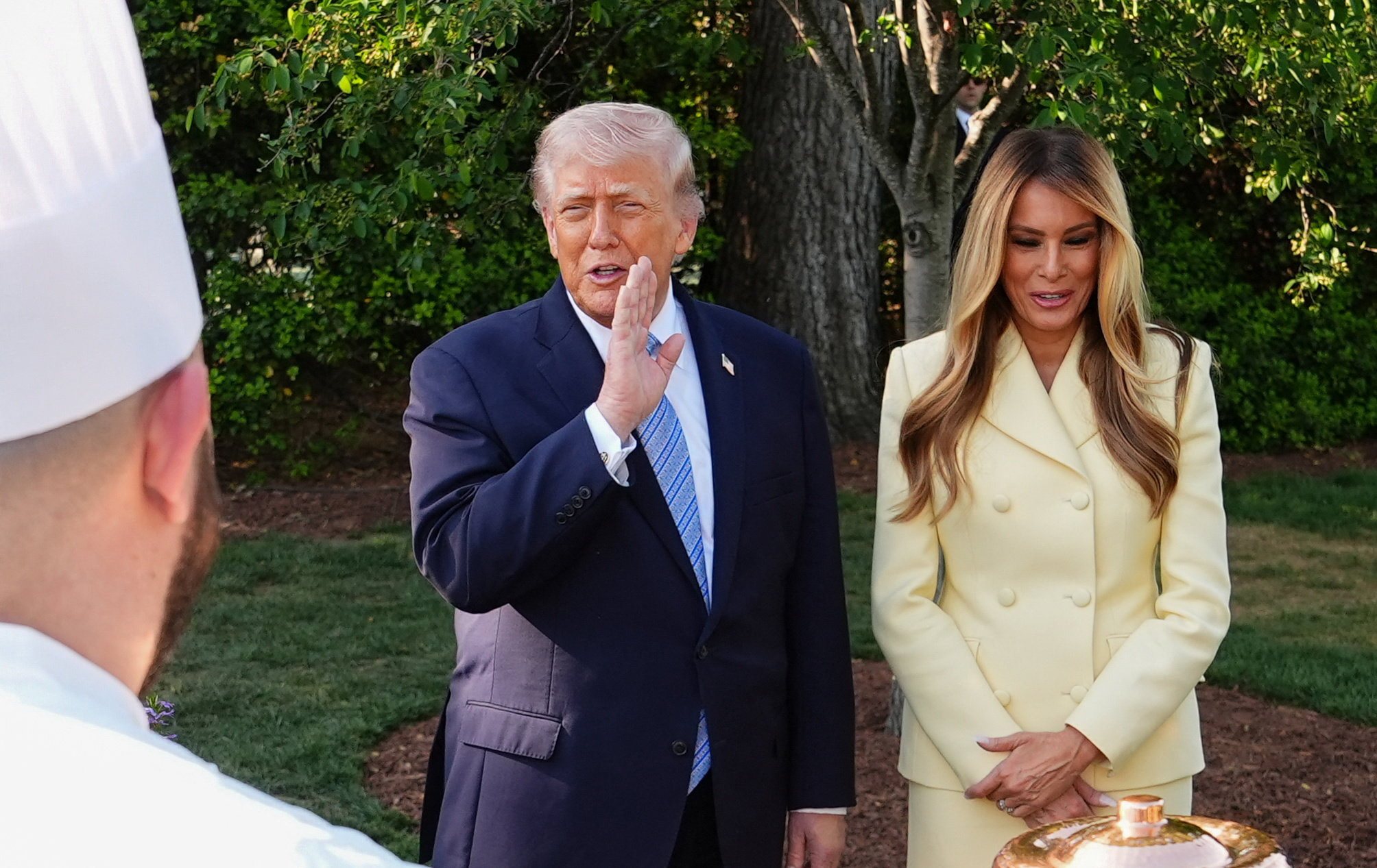 US President Donald Trump and US First Lady Melania stand together, as they tour the White House beehives in the grounds of the White House with Britain's King Charles and Queen Camilla (not pictured) on day one of the state visit to the US
