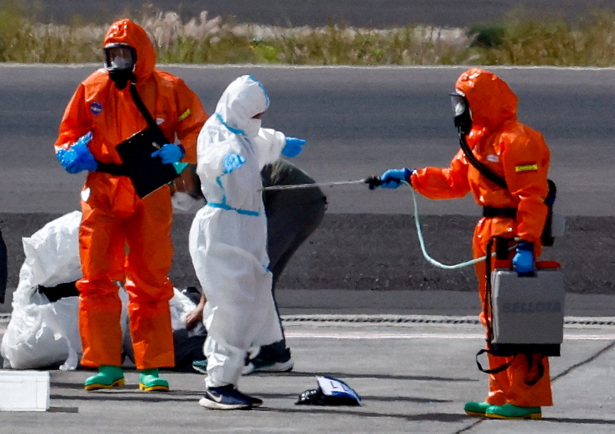 FILE PHOTO: A passenger of the cruise ship MV Hondius, which was affected by a hantavirus outbreak, gets disinfected on the tarmac at Tenerife Sud airport,  Canary Islands, Spain, May 10, 2026.