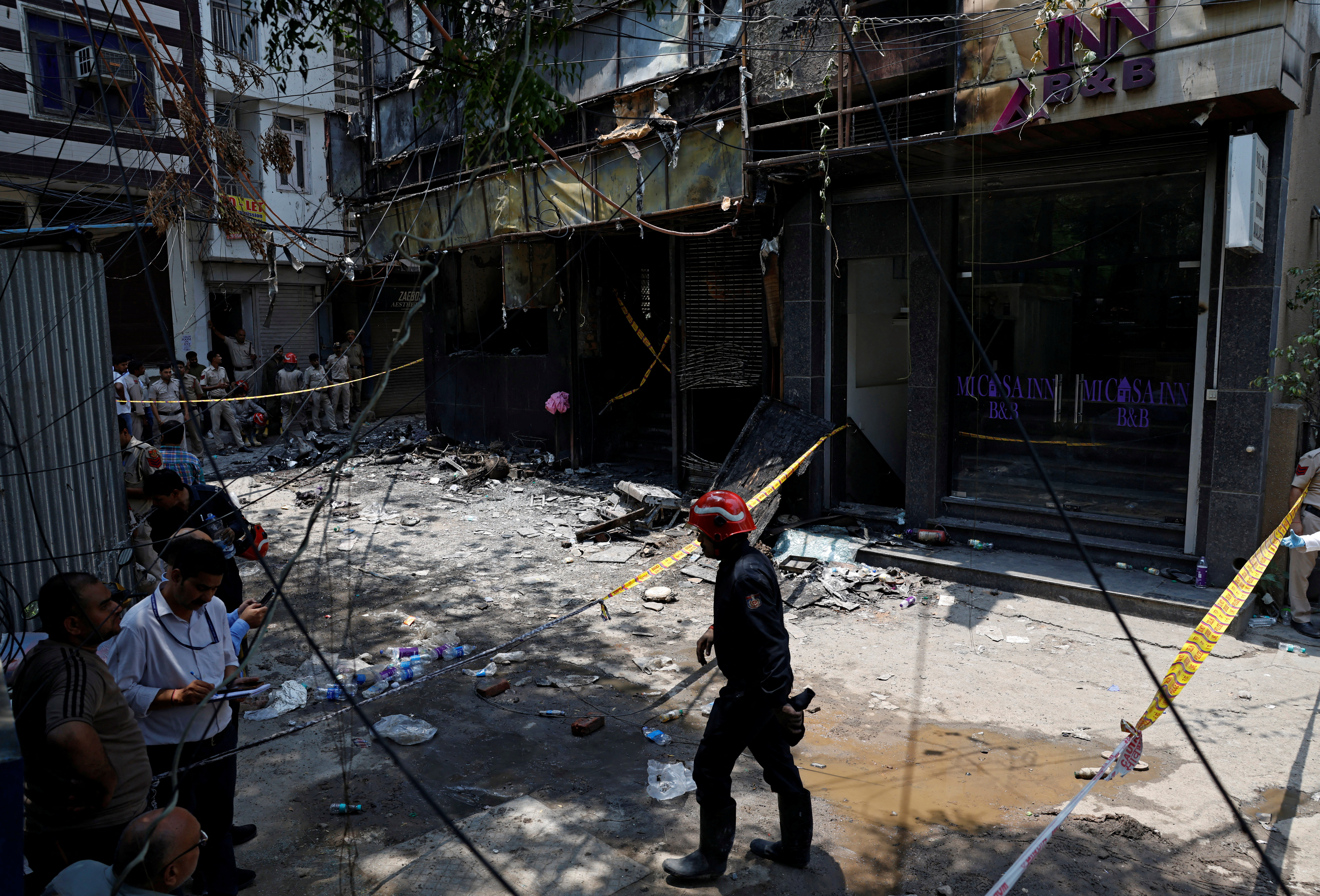 Firefighters and police officers work at the site after a fire at a hotel in New Delhi, India, June 3, 2026. REUTERS/Adnan Abidi